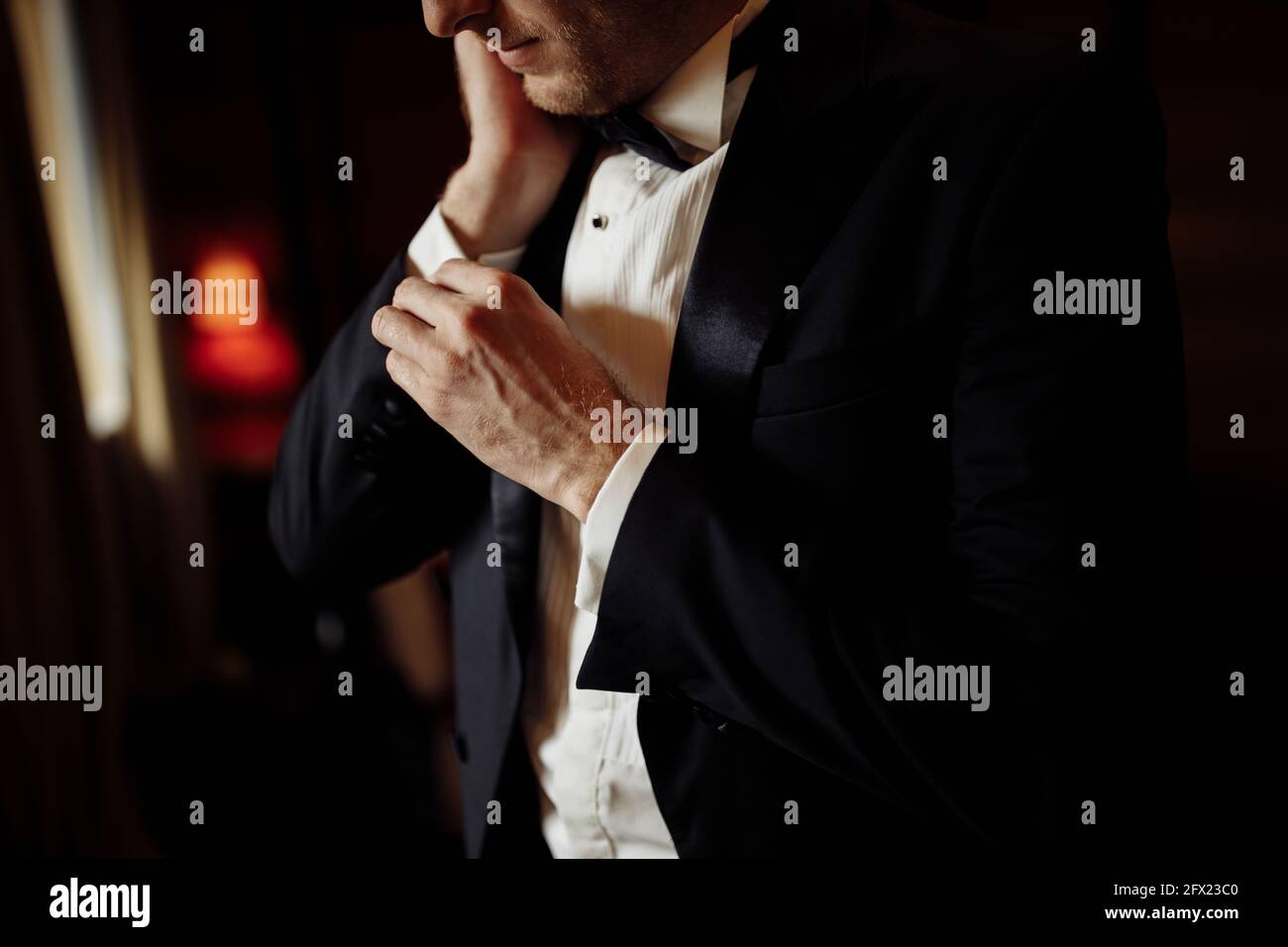 Un gros plan d'une coupe courte d'un marié d'homme dans un costume classique coûteux, et chemise blanche se préparer pour l'événement. Le futur mari est pressé Banque D'Images