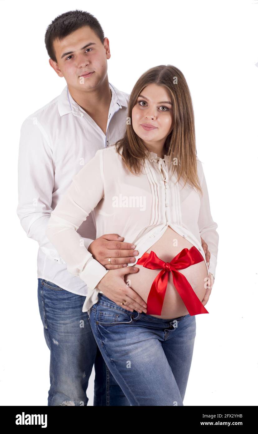 Un homme et une femme enceinte en jeans et chemises blanches. Ruban rouge  attaché autour du ventre d'une femme enceinte sur fond blanc Photo Stock -  Alamy