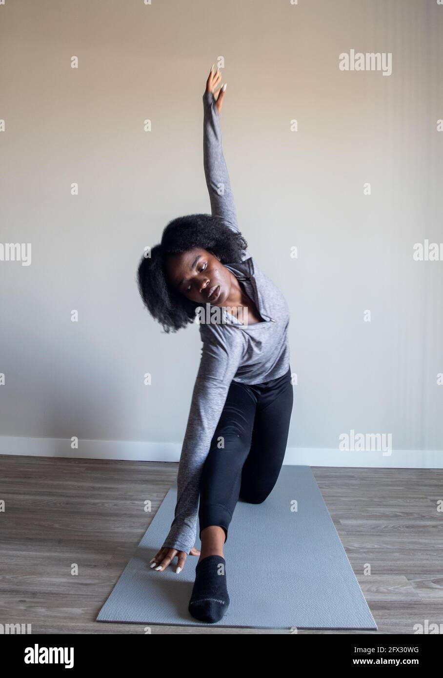 Femme pratiquant le yoga asana dans un studio à domicile. Fitness yoga, relaxation, femme noire, afro-américaine, cheveux naturels, une personne, gros plan, Banque D'Images