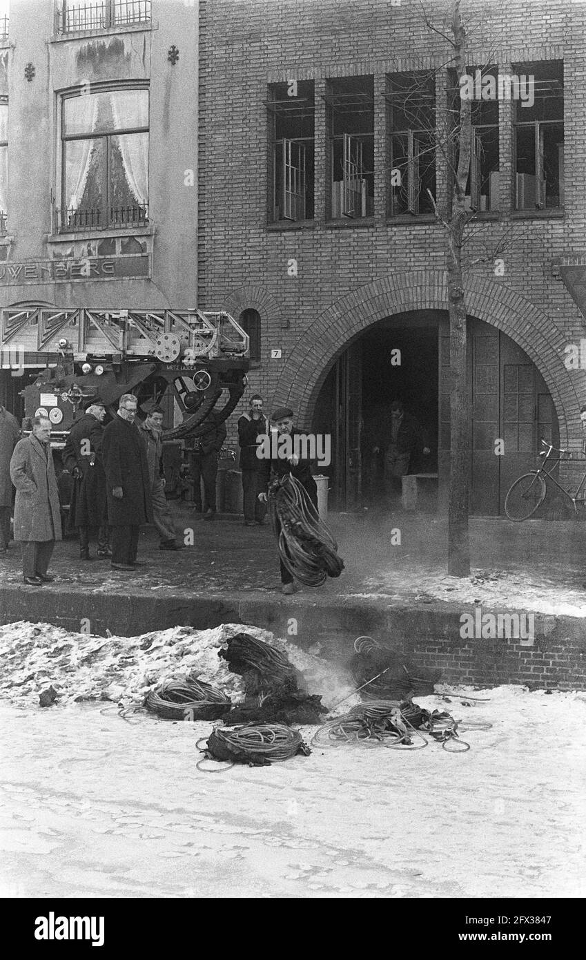 Feu moyen à IJzerwarengroothandel Van Leeuwen sur le Groenburgwal 3-17, les tuyaux en plastique de jardin sont projetés sur la glace du Groenburgwal, 26 février 1963, TUINSLANGEN, incendies, Pays-Bas, Agence de presse du XXe siècle photo, nouvelles à retenir, documentaire, photographie historique 1945-1990, histoires visuelles, L'histoire humaine du XXe siècle, immortaliser des moments dans le temps Banque D'Images