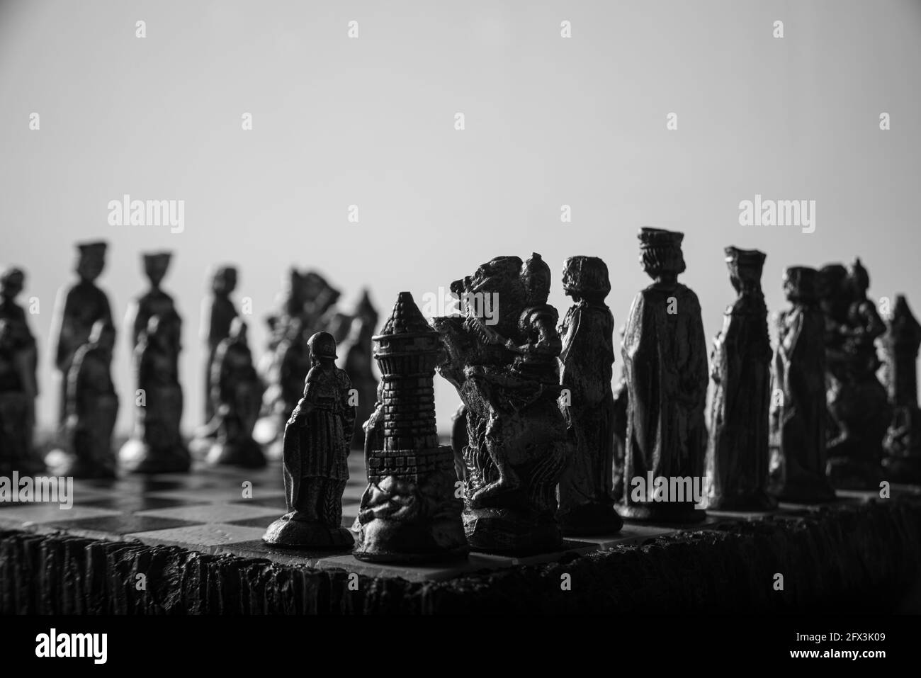 pièces d'échecs stylisées sur un plateau avec fond noir, foyer sélectif Banque D'Images
