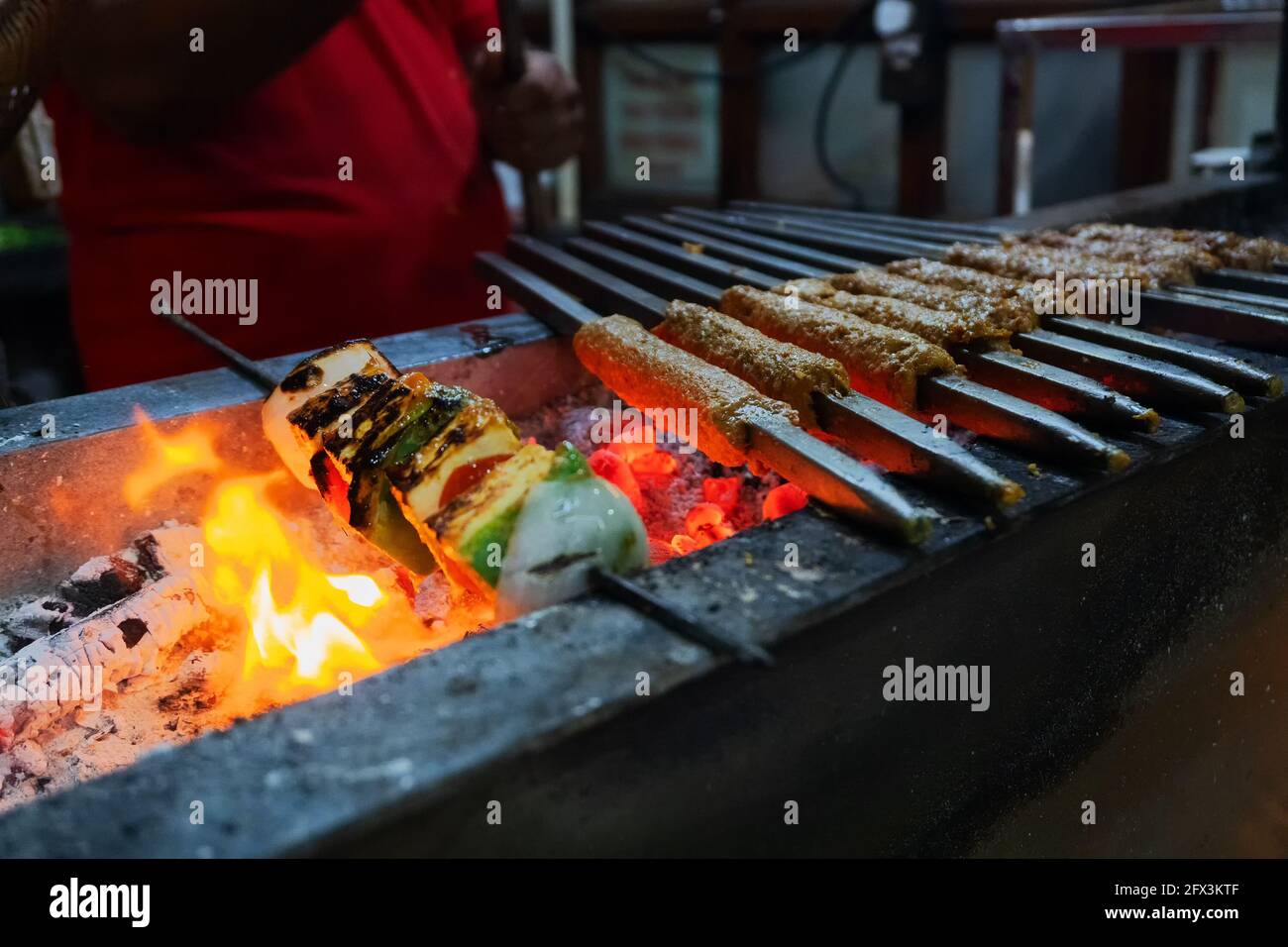 Des Brochettes De Poulet Épicées Sont Grillées Avec Du Charbon De Bois Dans  Un Barbecue Avec Des Brochettes En Métal, Le Soir À Vendre Comme Nourriture  De Rue Sur Le Marché Du