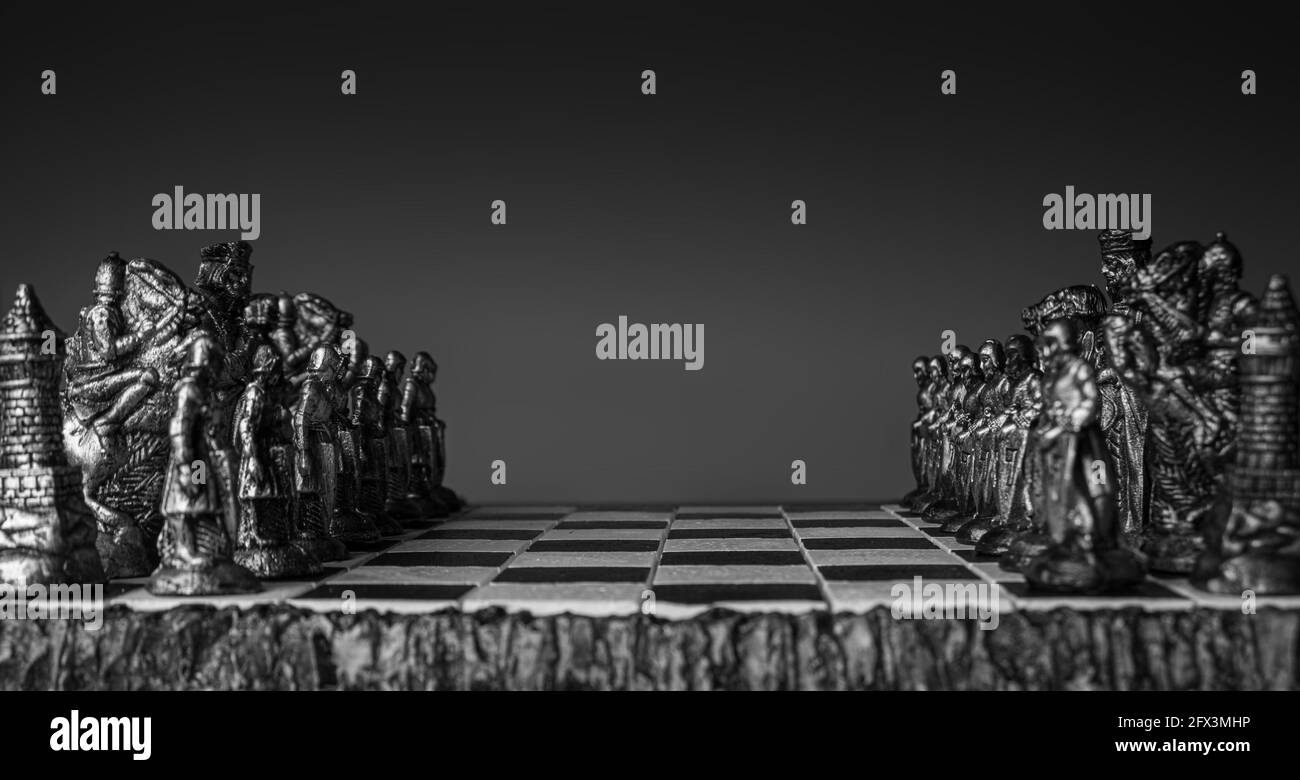 pièces d'échecs stylisées sur un plateau avec fond noir, foyer sélectif Banque D'Images