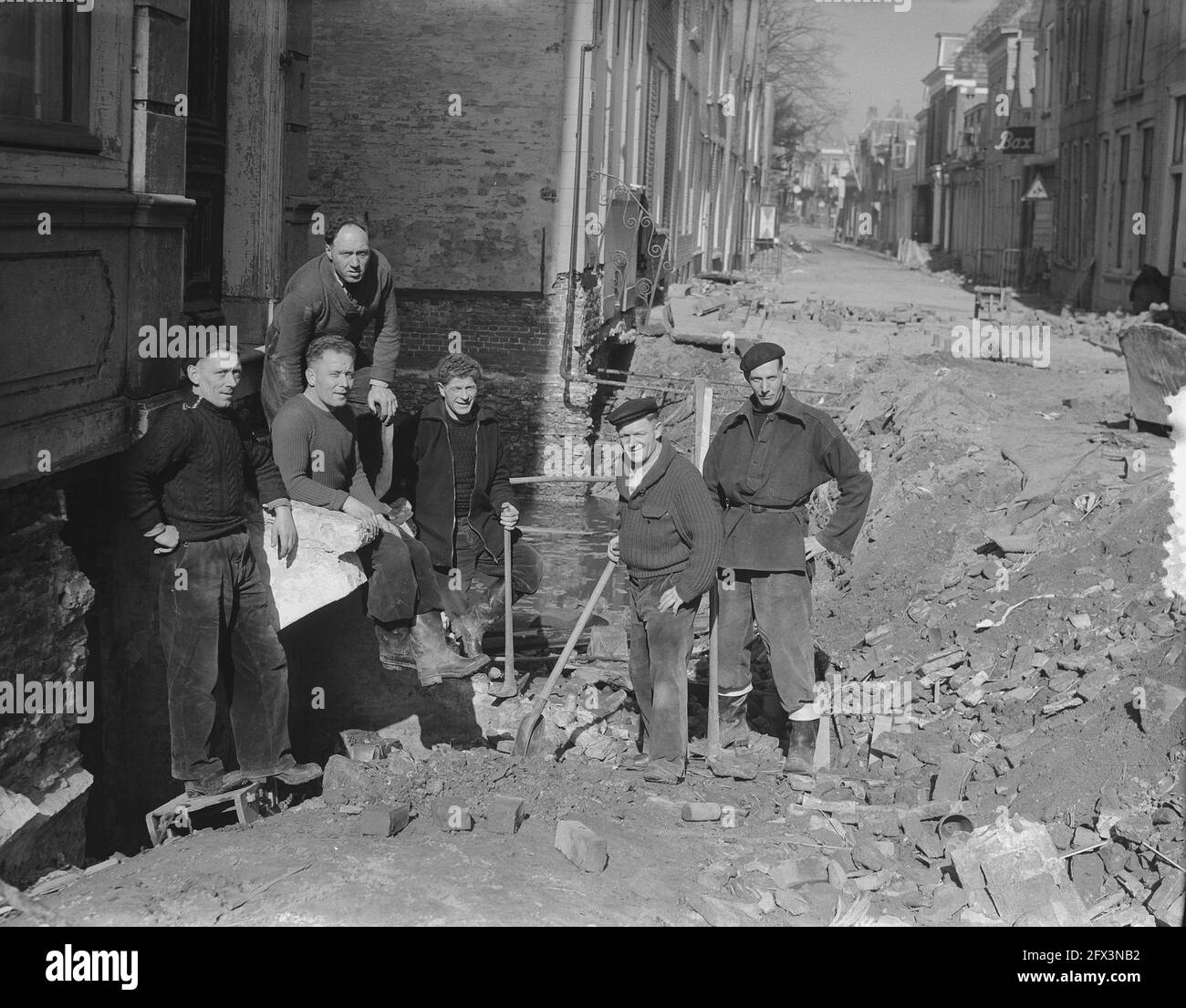 Les finisseurs d'Amsterdam aident à réparer les dommages causés par l'inondation de 1953. Ici, ils travaillent dans la Nieuwe Bogerdstraat à Zierikzee. Henk Jurgens, Karel Hofstede, Nico Lammers, Tinus Gietermans, Gerrit Oosterhuis et Bertus (nom de famille inconnu), 17 mars 1953, réparations, paveurs, Flood, pays-Bas, Agence de presse du XXe siècle photo, news to Remember, documentaire, photographie historique 1945-1990, histoires visuelles, L'histoire humaine du XXe siècle, immortaliser des moments dans le temps Banque D'Images