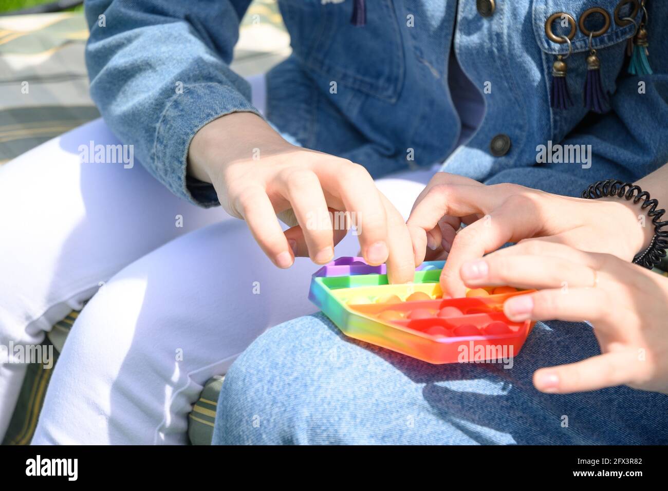 Adolescentes jouant avec le silicone sensoriel anti stress Pop IT jouet hexagonal. Gros plan. Banque D'Images