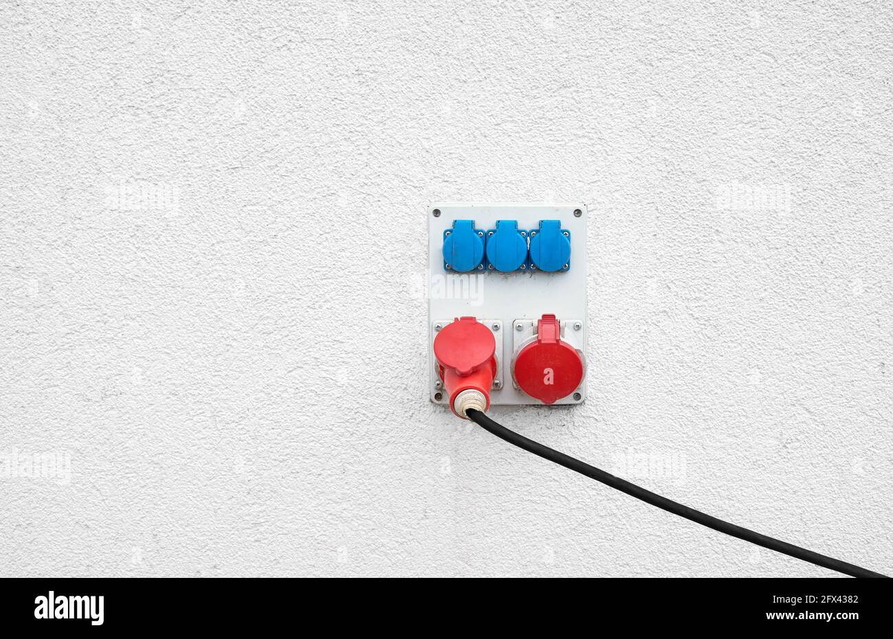 Prises industrielles haute tension montées sur un mur blanc. Banque D'Images