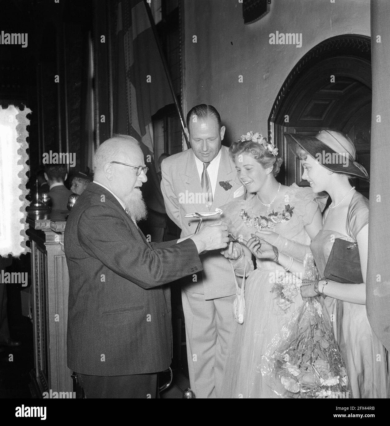 La nouvelle acquisition de la K.L.M. la Super Constellation s'est présentée à Copenhague lors d'un vol d'introduction au cours duquel la reine des fleurs de la Haye, ses dames en attente et 51 journalistes nationaux et internationaux, photographes de presse et opérateurs de cinéma ont copiloté. Le maire Soerensen de Copenhague montre le modèle à l'échelle de l'avion jusqu'à la reine des fleurs de la Haye F. Halstede et la reine de beauté danoise. Un grand homme regarde sur], 12 août 1953, pays-Bas, agence de presse du XXe siècle photo, news to remember, documentaire, photographie historique 1945-1990, histoires visuelles, humain Banque D'Images