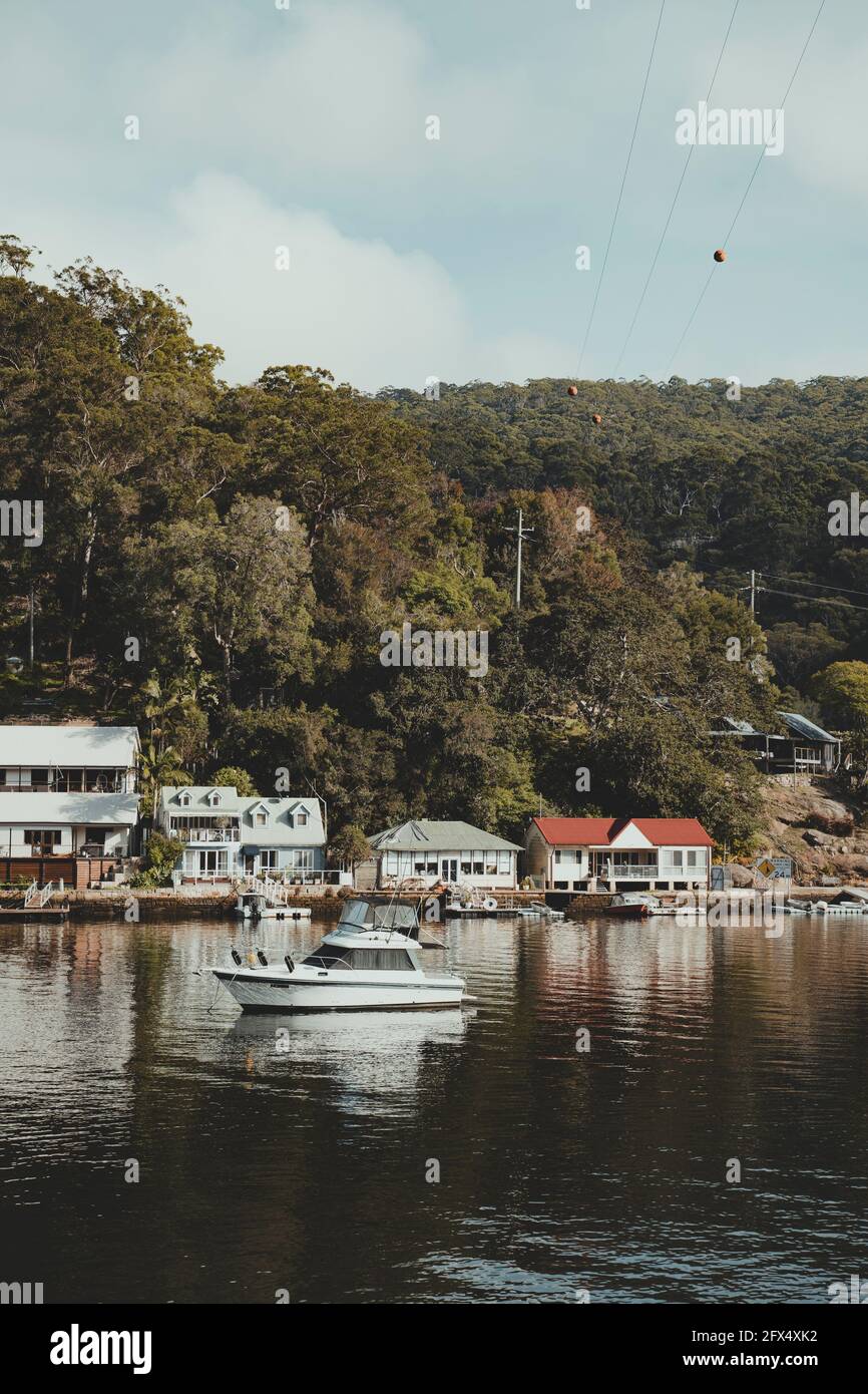 Bateaux sur l'eau devant des maisons idylliques en bord de mer à Berowra Waters, Nouvelle-Galles du Sud. Comme vu de la Great North Walk. Banque D'Images