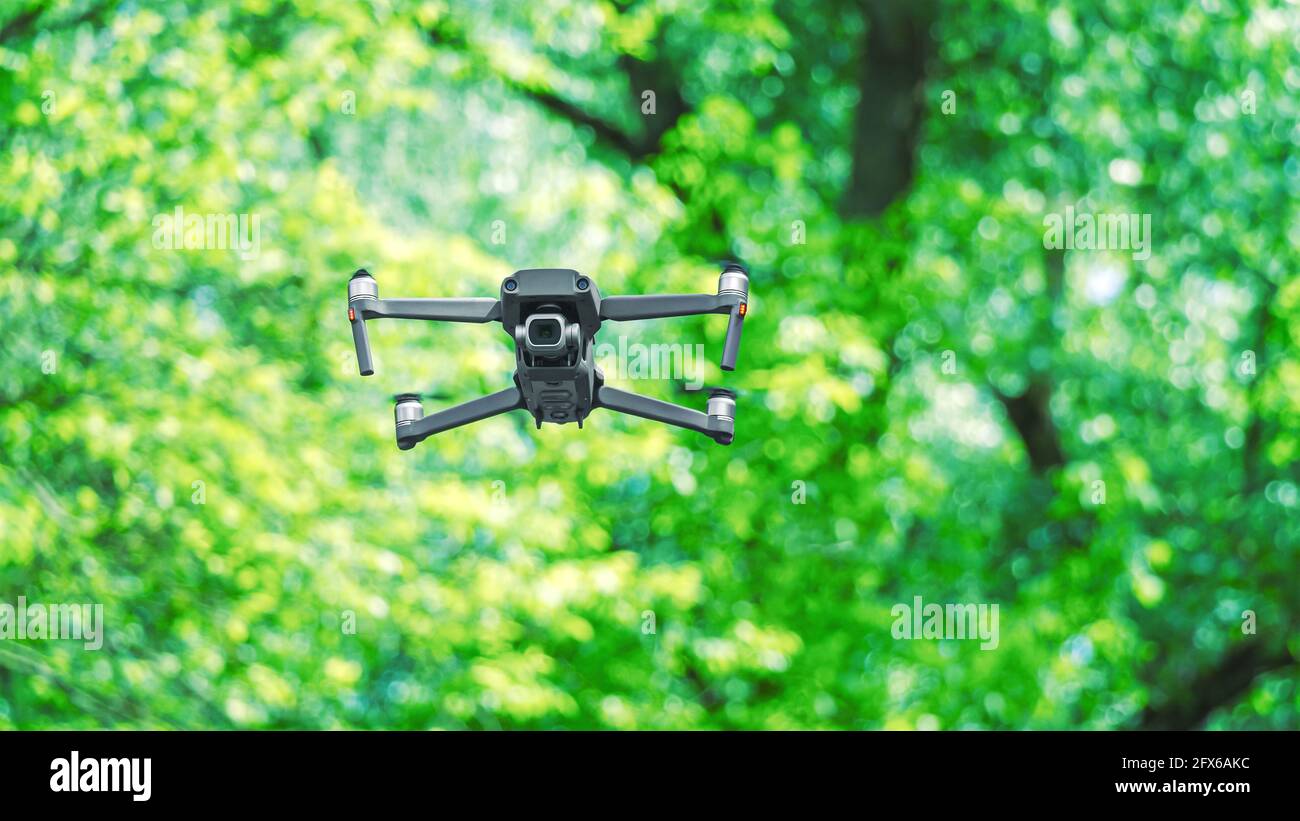 drone avec appareil photo professionnel volant dans la forêt arrière-plan arbres flous Banque D'Images