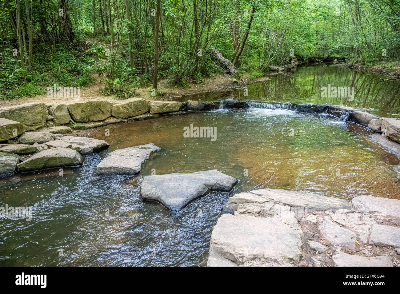 Ruisseau paisible avec sentier traversant des rochers au parc Ronald Reagan à Lawrenceville, Géorgie. (ÉTATS-UNIS) Banque D'Images