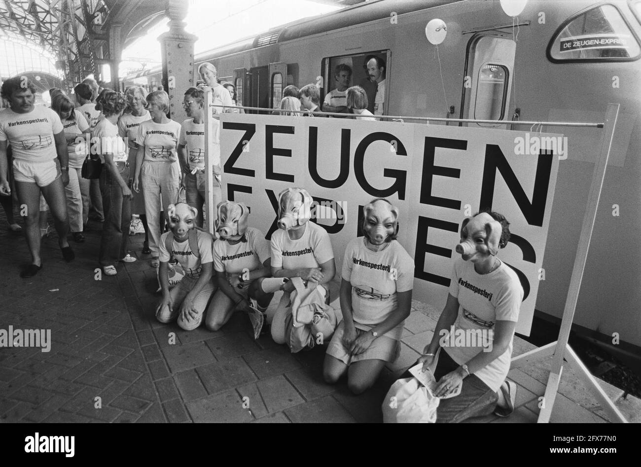 Activistes avec masques de la tête d'un porc devant une bannière SOW Express, 19 août 1983, actions, bio-industrie, Protection des animaux, masques, trains, porcs, pays-Bas, agence de presse du xxe siècle photo, nouvelles à retenir, documentaire, photographie historique 1945-1990, histoires visuelles, L'histoire humaine du XXe siècle, immortaliser des moments dans le temps Banque D'Images