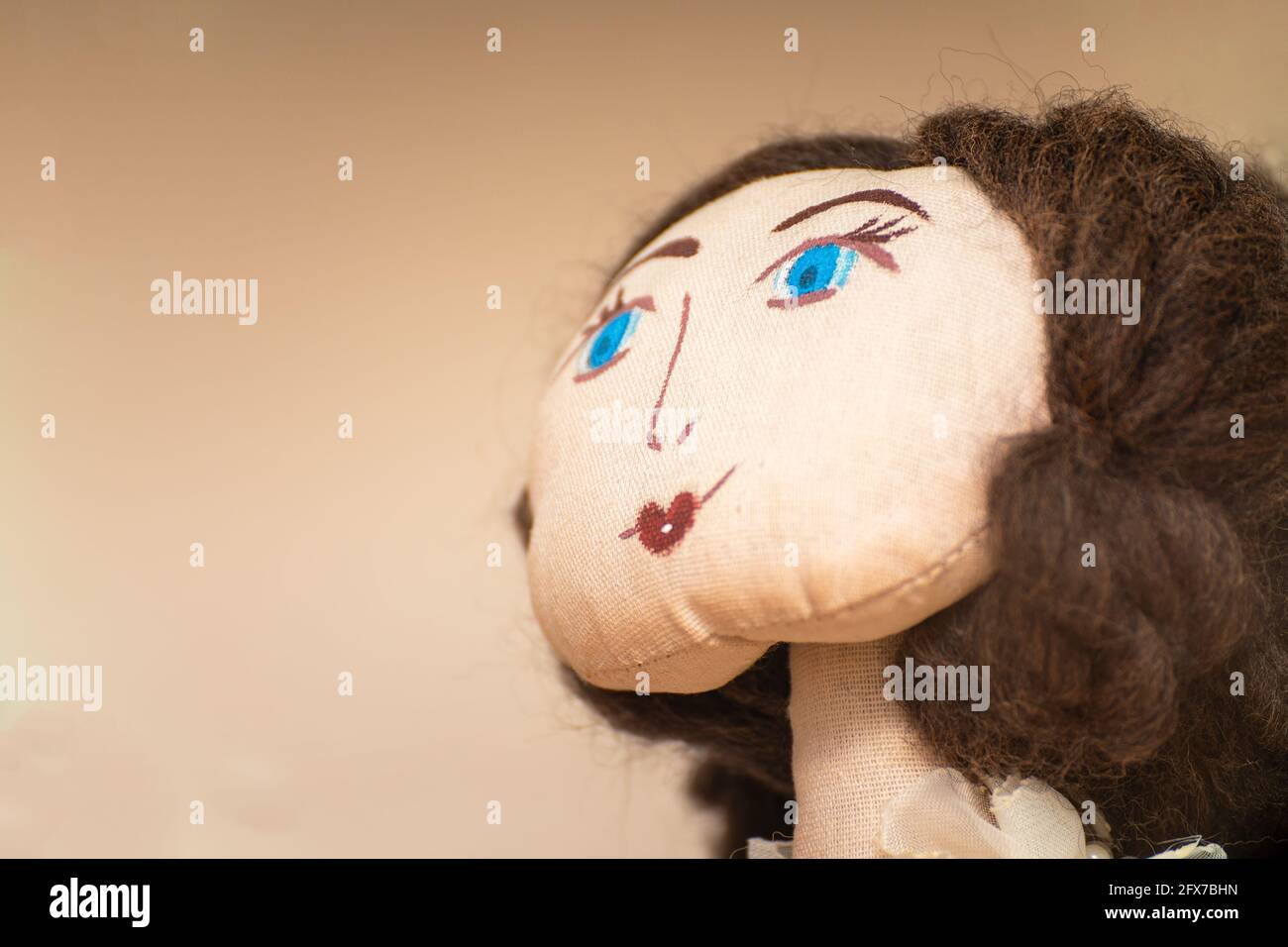 Le visage d'une poupée de chiffon maison avec des yeux bleus. Portrait d'une poupée de chiffon. Mise au point sélective Banque D'Images