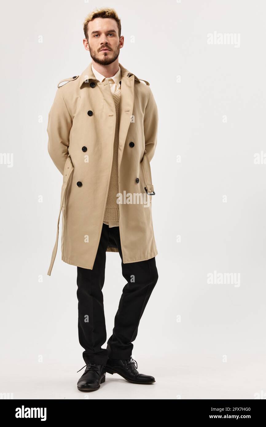 homme avec une expression sérieuse beige manteau mode moderne style  longueur totale Photo Stock - Alamy