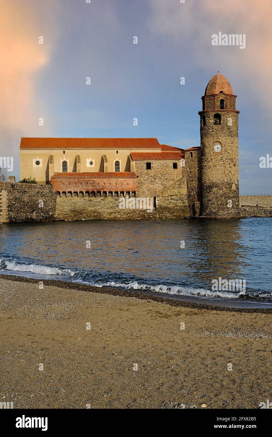 Église notre-Dame-des-Anges, Collioure, Pyrénées-Orientales, Occitanie, France. Le beffroi de l’église, aujourd’hui surmonté d’un dôme rose de style toscan, a été construit initialement comme un phare médiéval de pharos et a signalé l’emplacement de l’ancien port de commerce aux navires en mer avec de la fumée le jour et du feu la nuit. Le phare a été mis hors service en 1600s, lorsque Collioure a perdu sa fonction principale dans les eaux plus profondes de Port-Vendres, et en 1693, la tour a été transformée en clocher ou campanile. Banque D'Images