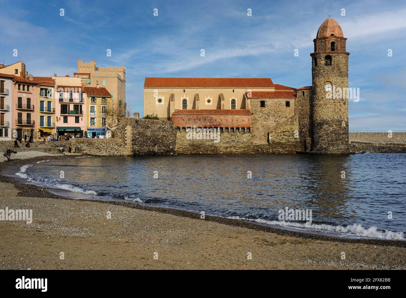 Église notre-Dame-des-Anges, Collioure, Pyrénées-Orientales, Occitanie, France. Le beffroi de l’église, aujourd’hui surmonté d’un dôme rose de style toscan, a été construit initialement comme un phare médiéval de pharos et a signalé l’emplacement de l’ancien port de commerce aux navires en mer avec de la fumée le jour et du feu la nuit. Le phare a été mis hors service en 1600s, lorsque Collioure a perdu sa fonction principale dans les eaux plus profondes de Port-Vendres, et en 1693, la tour a été transformée en clocher ou campanile. Banque D'Images