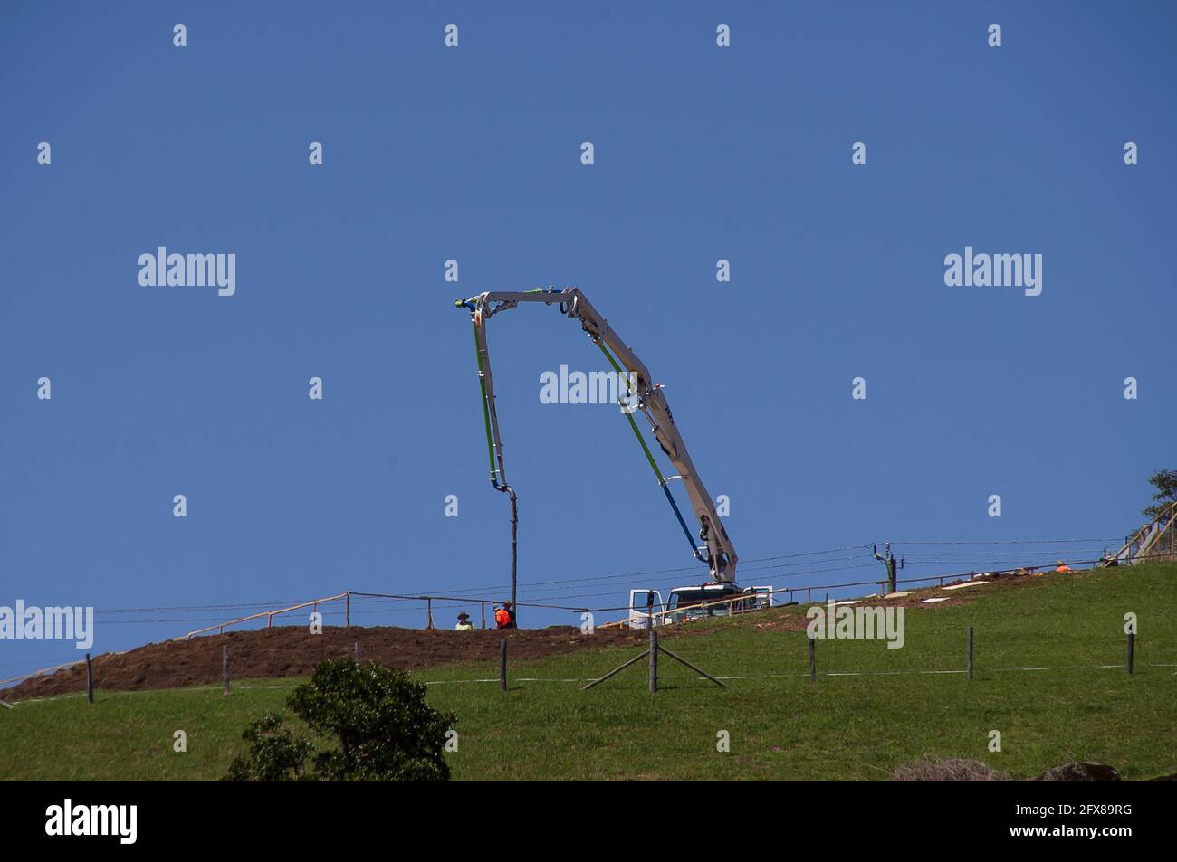 Pompe à béton, montée sur camion, posant les bases d'une nouvelle maison sur un site rural au sommet d'une colline, Queensland, Australie. Copier l'espace. Banque D'Images