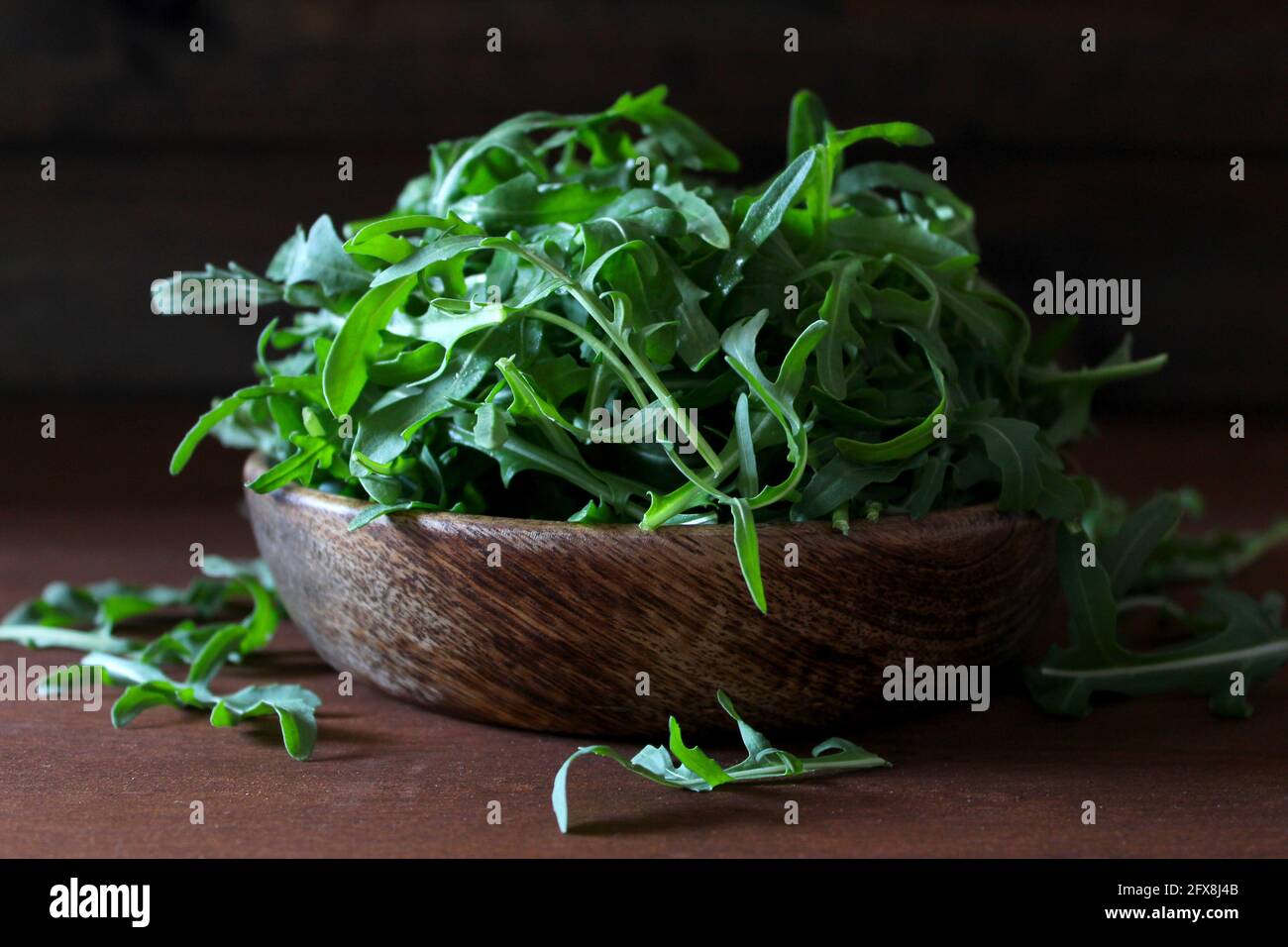 Feuilles d'arugula fraîches dans un bol en bois. Une alimentation saine. Vue de dessus avec espace de copie. Banque D'Images