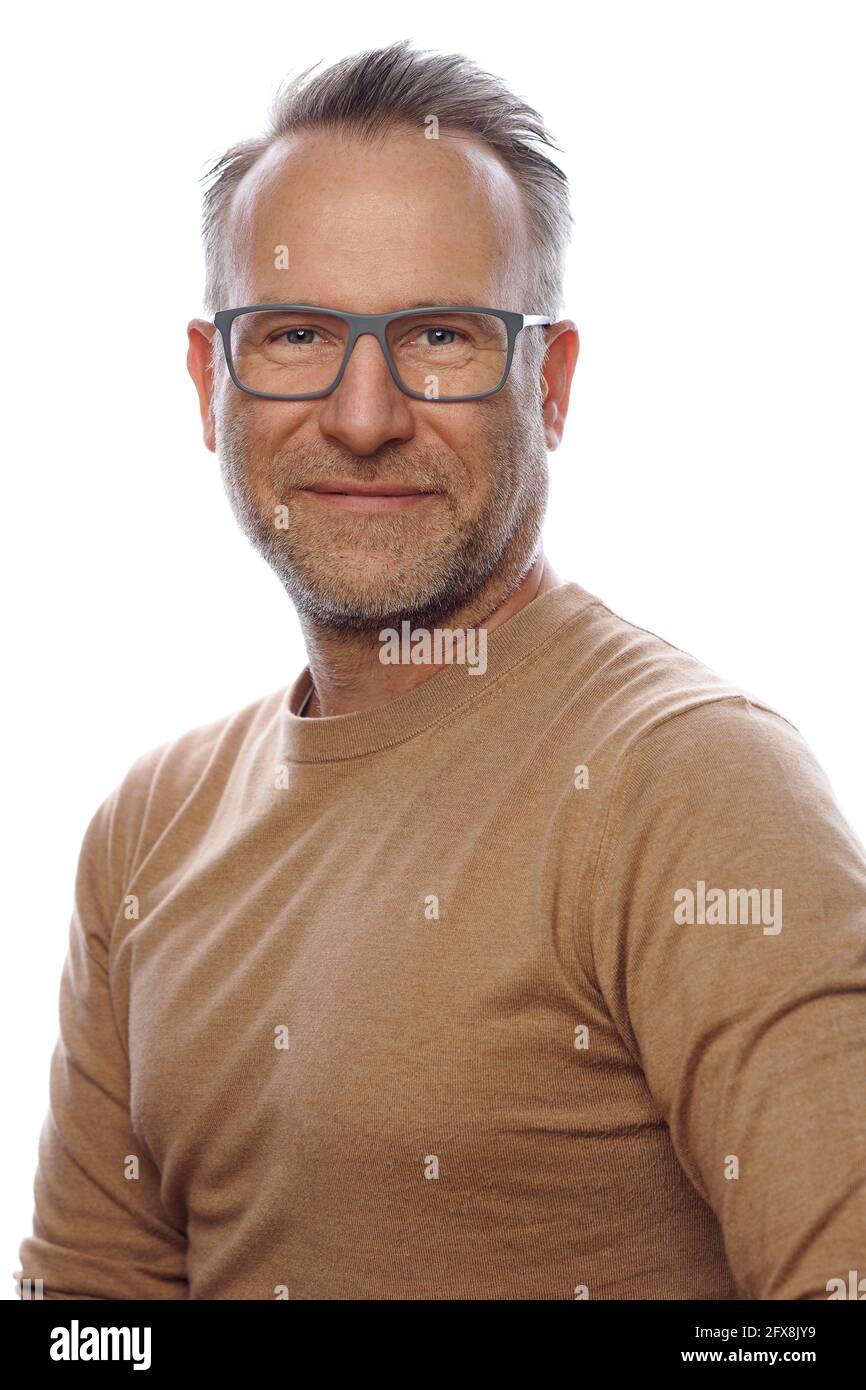 Souriant sympathique non rasé homme d'âge moyen en vêtements de loisirs portant des lunettes tournant pour regarder l'appareil photo dans un portrait du haut du corps sur blanc Banque D'Images