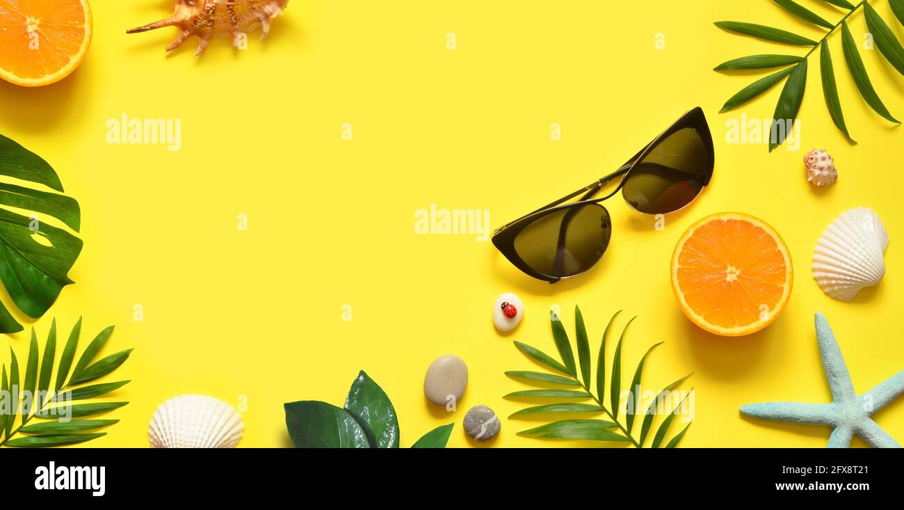 Arrière-plan d'été. Feuilles de palmier, orange, étoiles de mer et coquillages sur fond jaune. Déplacement. Copier l'espace. Banque D'Images