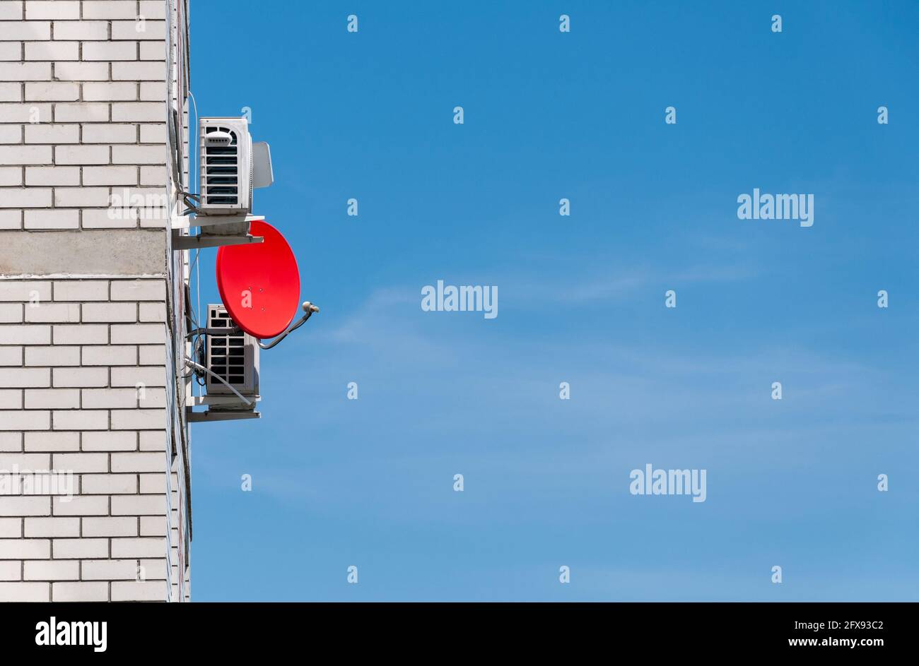 Antenne parabolique ou radio contre le ciel bleu. La parabole satellite pour regarder la télévision est située sur la façade du bâtiment. Technologie sans fil Banque D'Images