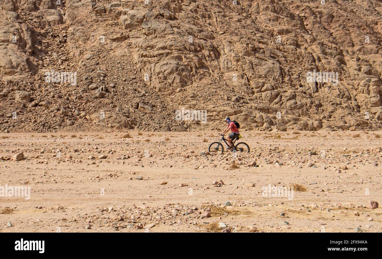 Paysage vue panoramique sur le désert de l'est déserte aride en Égypte avec des cyclistes d'aventure à vélo le long de la vallée de la rivière wadi Banque D'Images