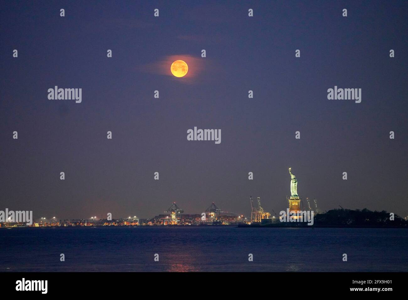 New York, États-Unis. 26 mai 2021. Une lune est vue au-dessus de la Statue de la liberté à New York, aux États-Unis, le 26 mai 2021. Une super lune a pu être observée mercredi dans certaines parties des États-Unis. Crédit : Wang Ying/Xinhua/Alay Live News Banque D'Images