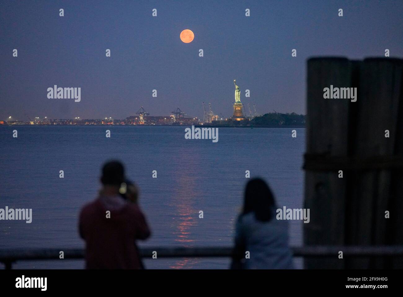 New York, États-Unis. 26 mai 2021. Une lune est vue au-dessus de la Statue de la liberté à New York, aux États-Unis, le 26 mai 2021. Une super lune a pu être observée mercredi dans certaines parties des États-Unis. Crédit : Wang Ying/Xinhua/Alay Live News Banque D'Images