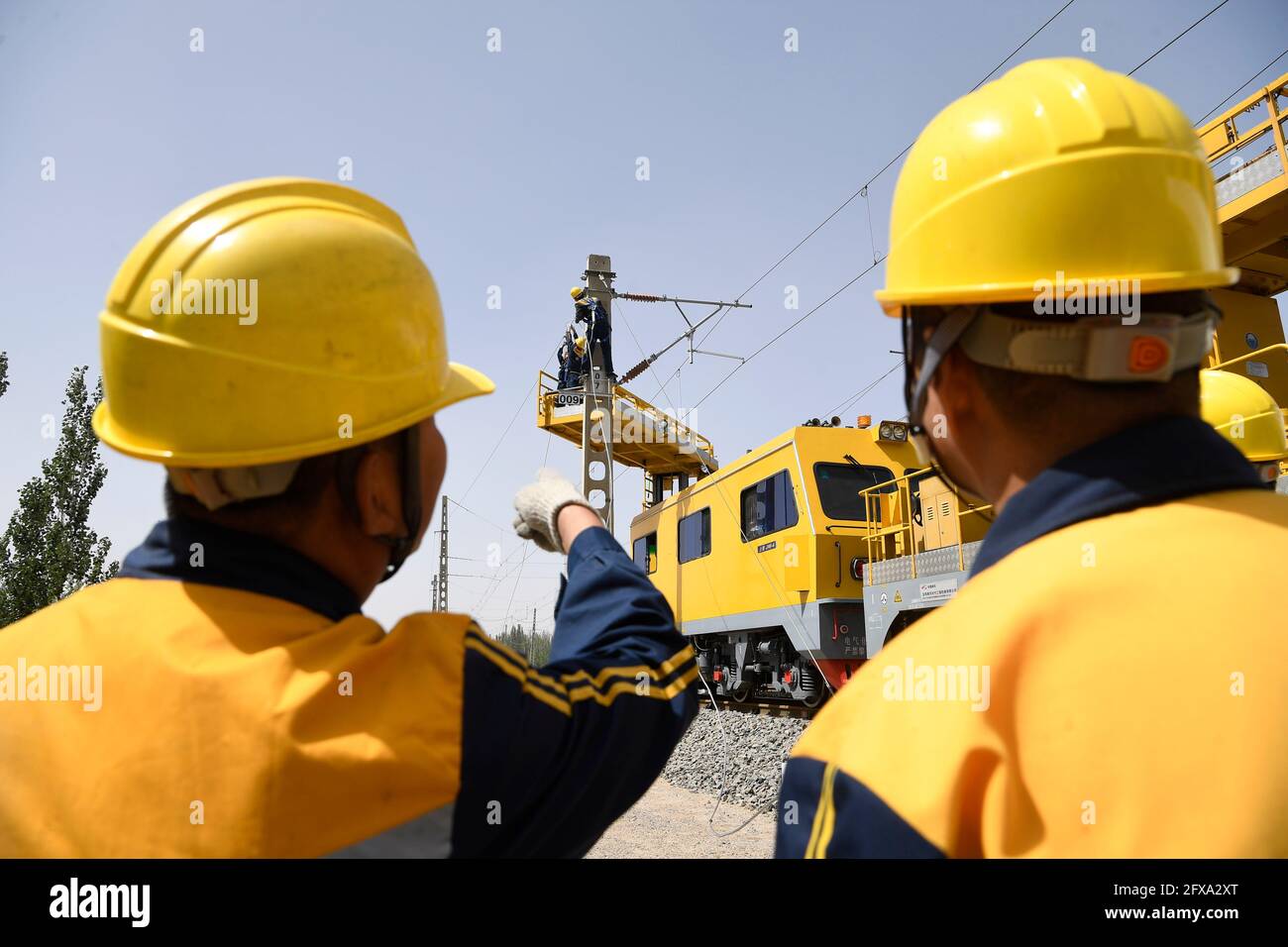 (210526) -- YINCHUAN, 26 mai 2021 (Xinhua) -- le personnel ferroviaire entretient l'équipement d'alimentation électrique dans une section ferroviaire de Yinchuan, dans la région autonome de Ningxia hui, dans le nord-ouest de la Chine, le 26 mai 2021. Les objets à lumière aléatoire tels que les cerfs-volants cassés, les ballons flottants et les films en plastique dérivant constituent des menaces importantes pour l'exploitation en toute sécurité des lignes de chemin de fer à grande vitesse, affectant l'ordre du réseau ferroviaire ou causant au pire des dommages irréversibles à l'équipement du système de contact aérien. Le devoir d'un groupe de membres du personnel ferroviaire est de patrouiller régulièrement les routes pour nettoyer ces objets f Banque D'Images