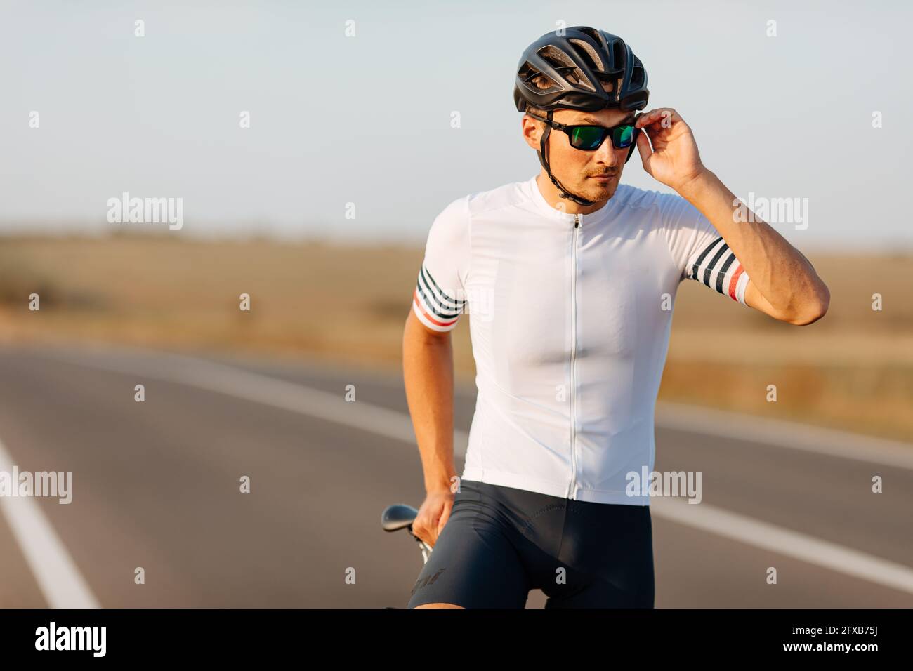 Portrait d'un cycliste élégant en tenue de sport qui pose à l'extérieur Banque D'Images
