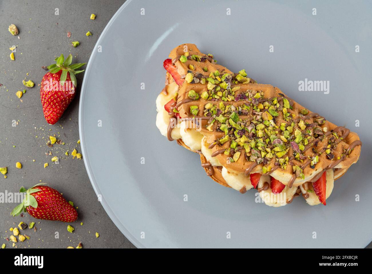 gaufres à croque-monsieur avec banane, fraise et chocolat et pistache sur le dessus Banque D'Images