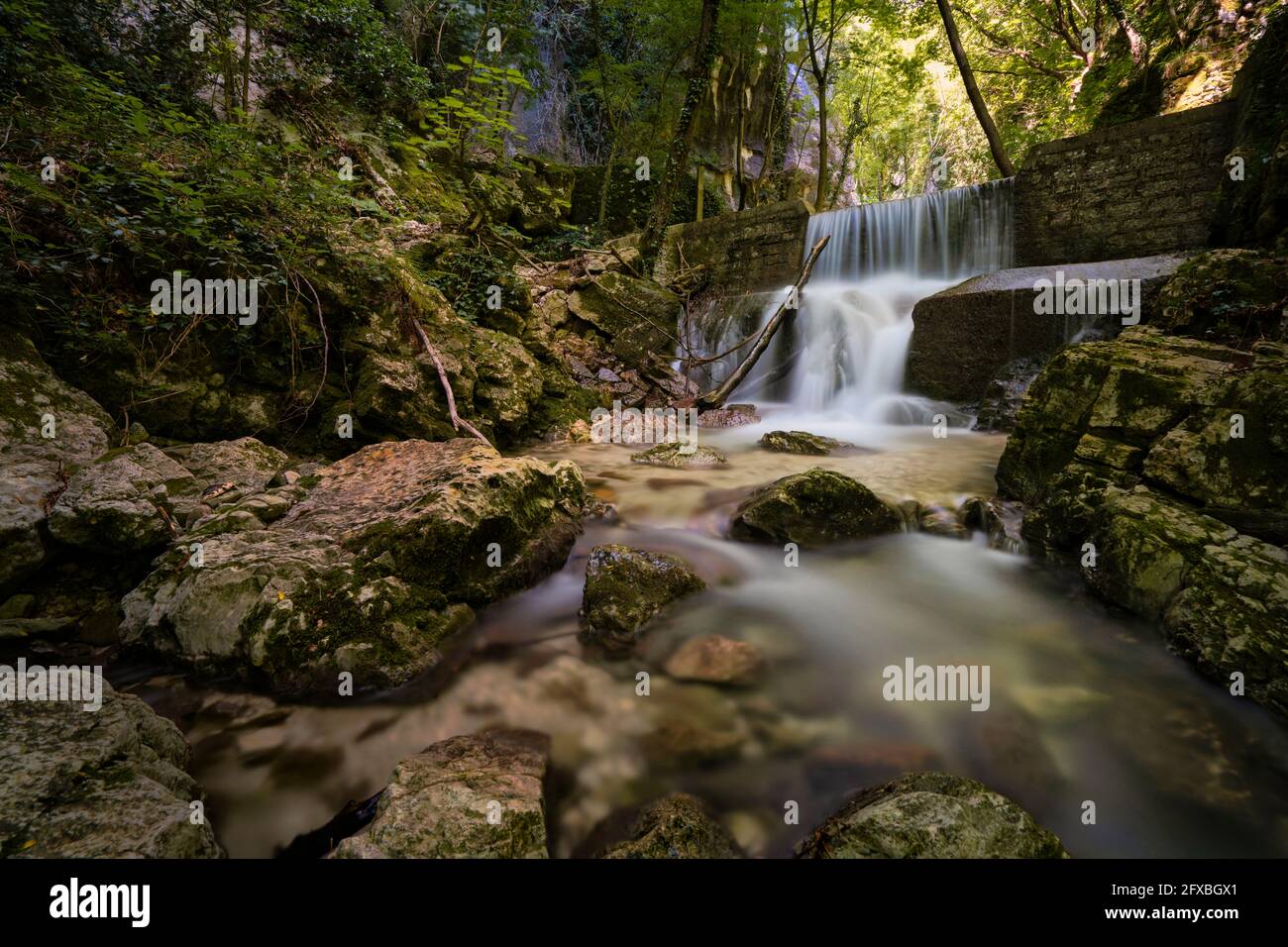 Longue exposition d'une petite cascade forestière dans le parc Monte Cucco, Ombrie, Italie Banque D'Images