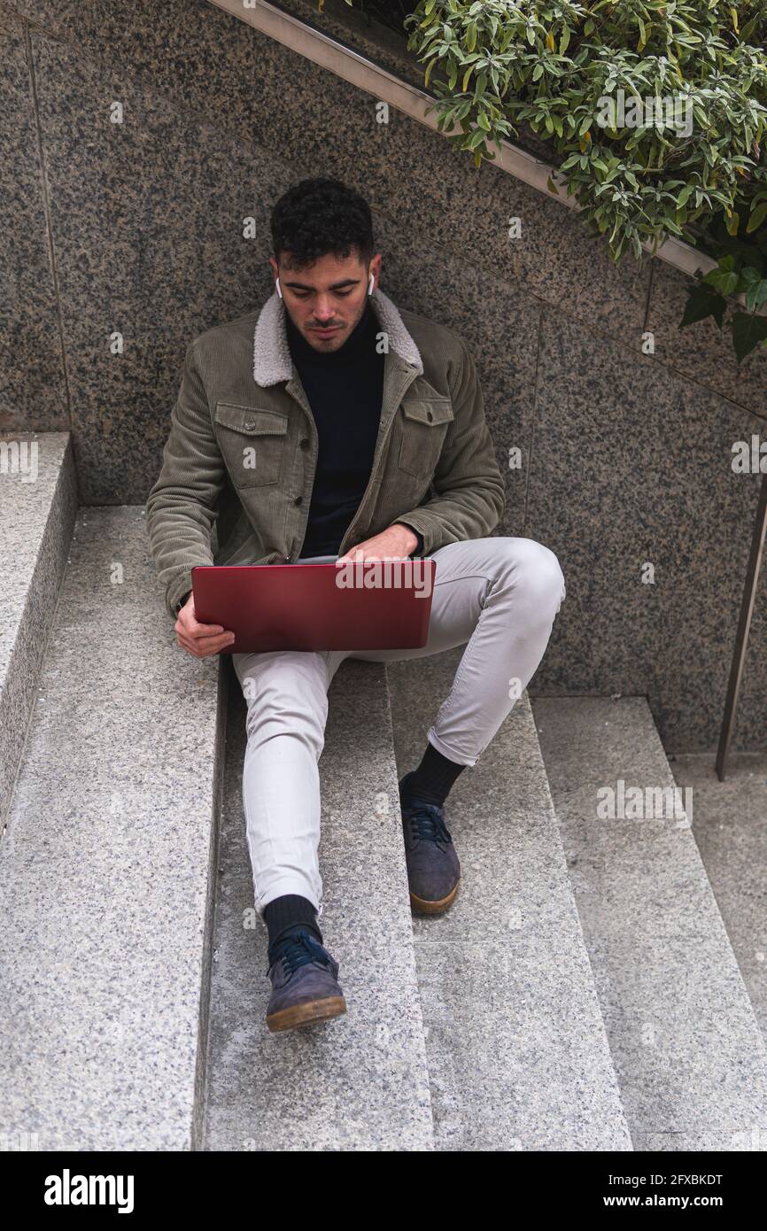 Homme d'affaires travaillant sur un ordinateur portable assis sur des marches Banque D'Images