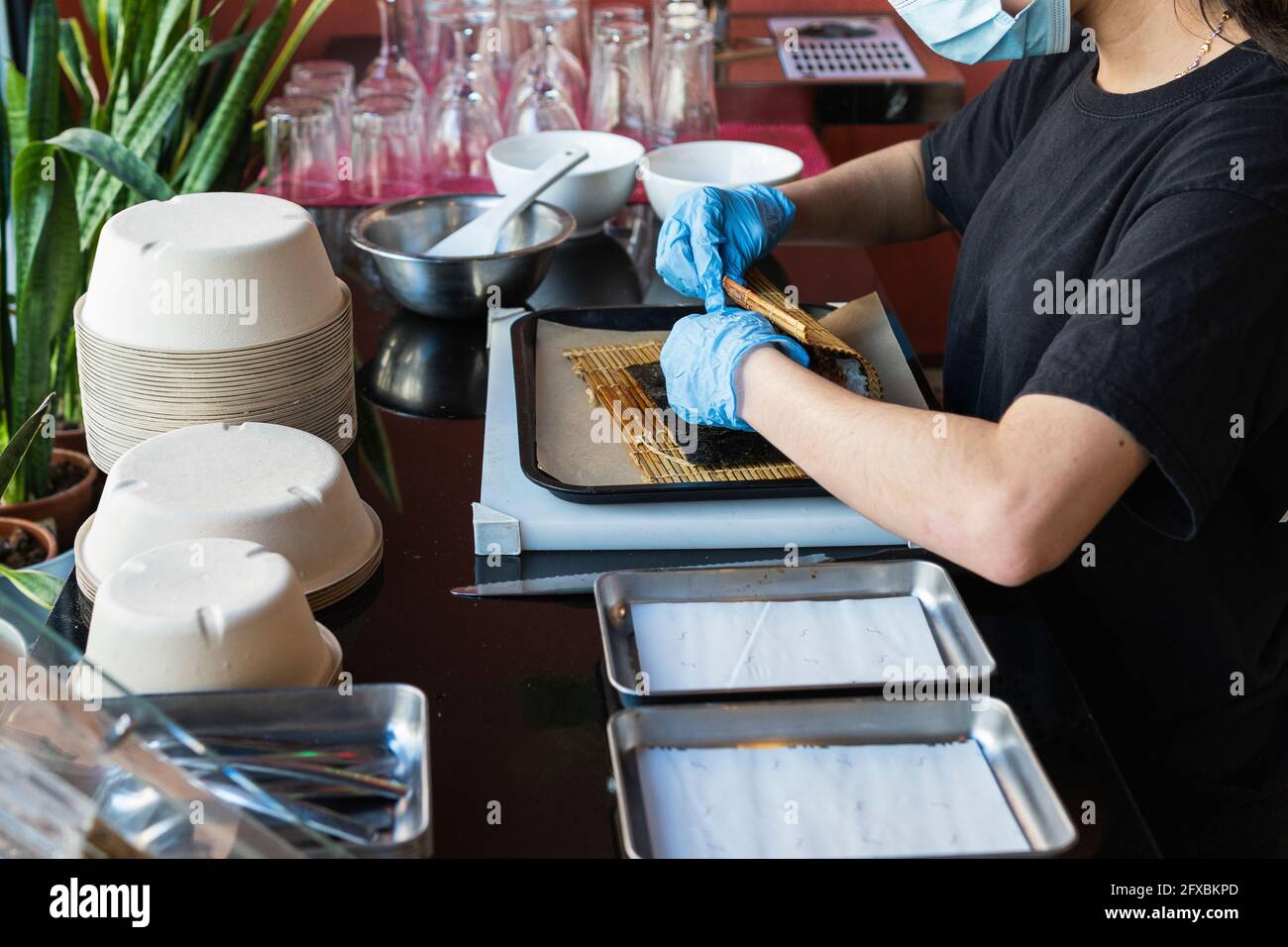La serveuse emballant les aliments sur le plateau du restaurant pendant la période COVID-19 Banque D'Images