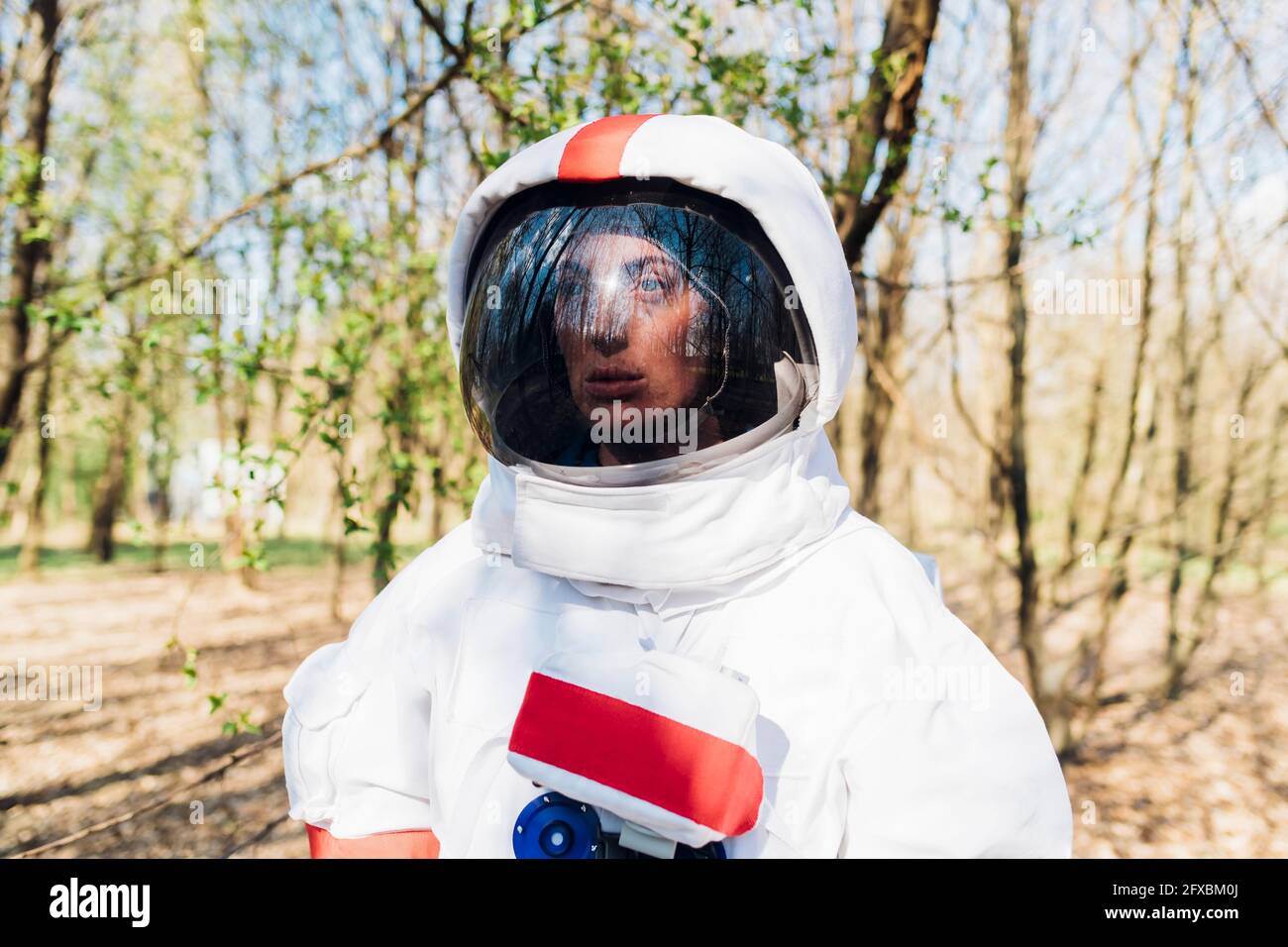 Femme exploratrice attentionnés dans un costume d'espace et un casque en forêt Banque D'Images