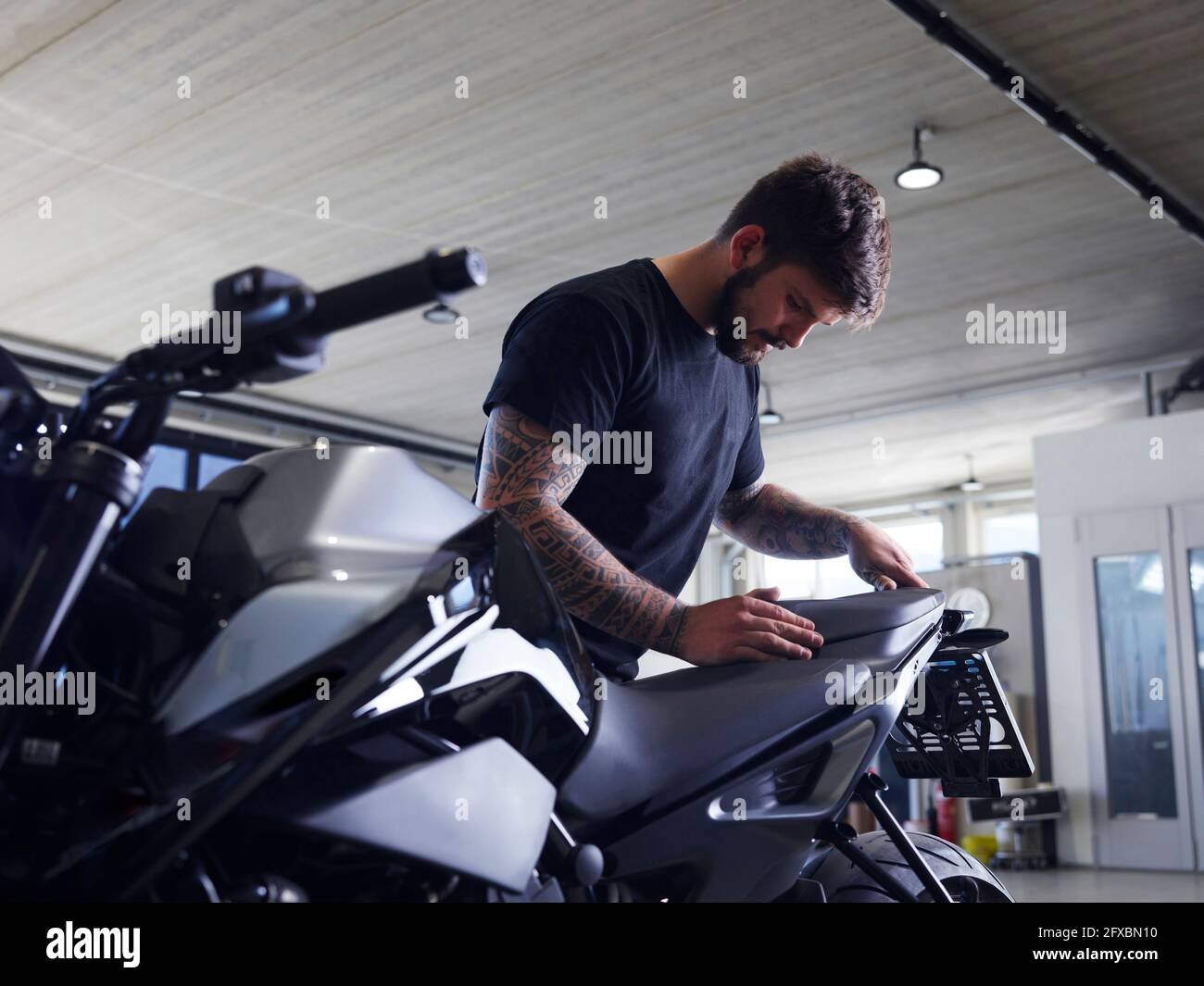 Réparateur installant le siège de moto à l'atelier Banque D'Images