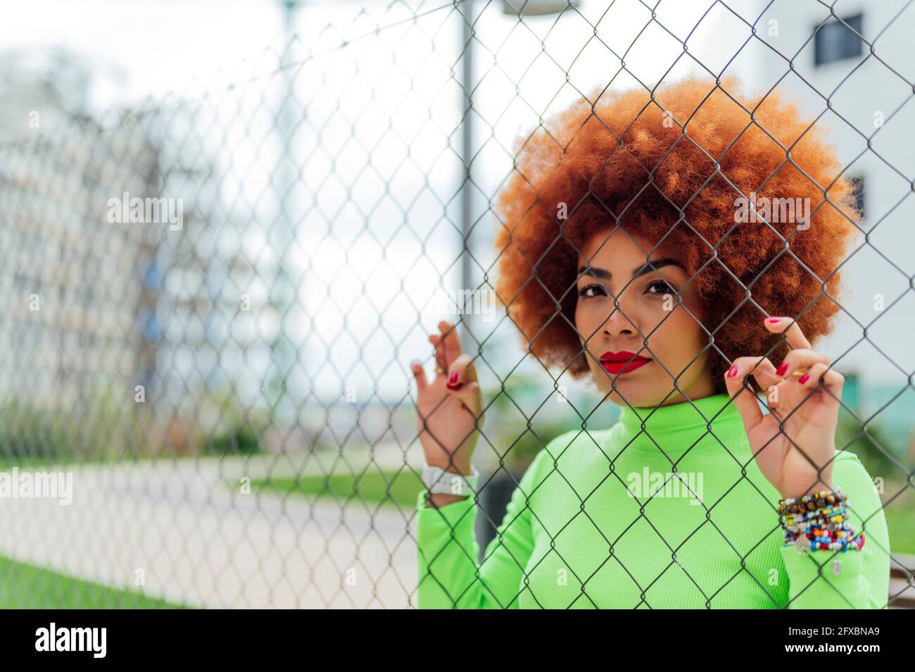 Femme afro derrière la clôture dans le parc Banque D'Images