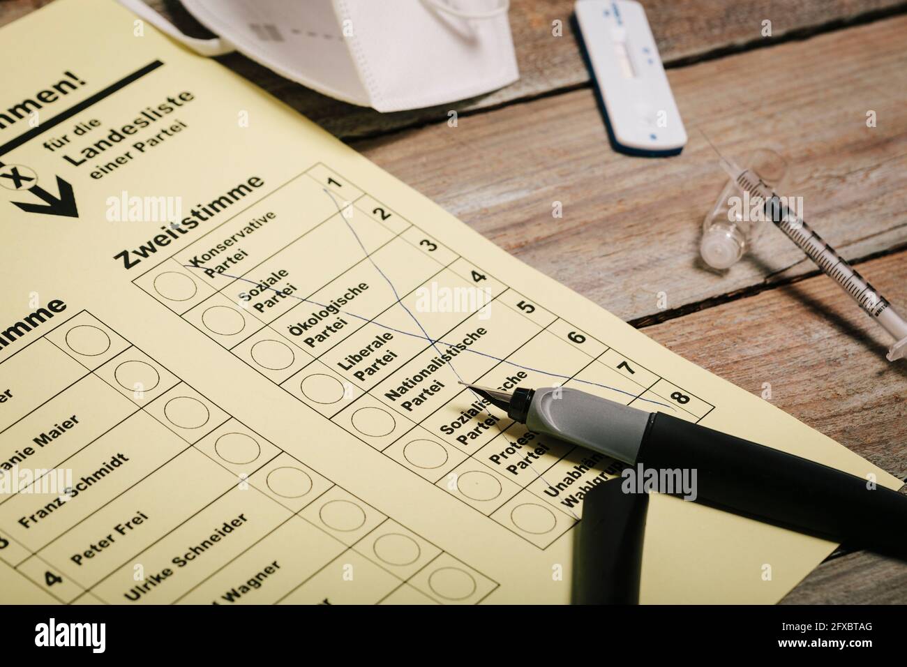 Bulletin de vote et stylo sur la table avec masque de protection et test rapide de corona Banque D'Images Bulletin de vote et stylo sur la table avec masque de protection et test rapide de corona Banque D'Images