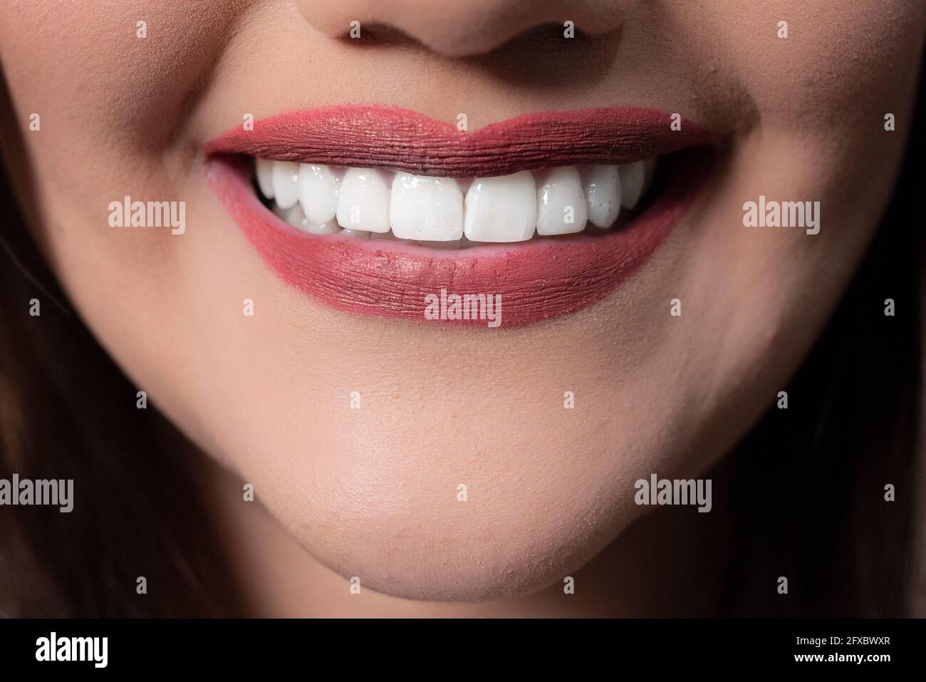 Femme avec rouge à lèvres et sourire en dents de souris Banque D'Images