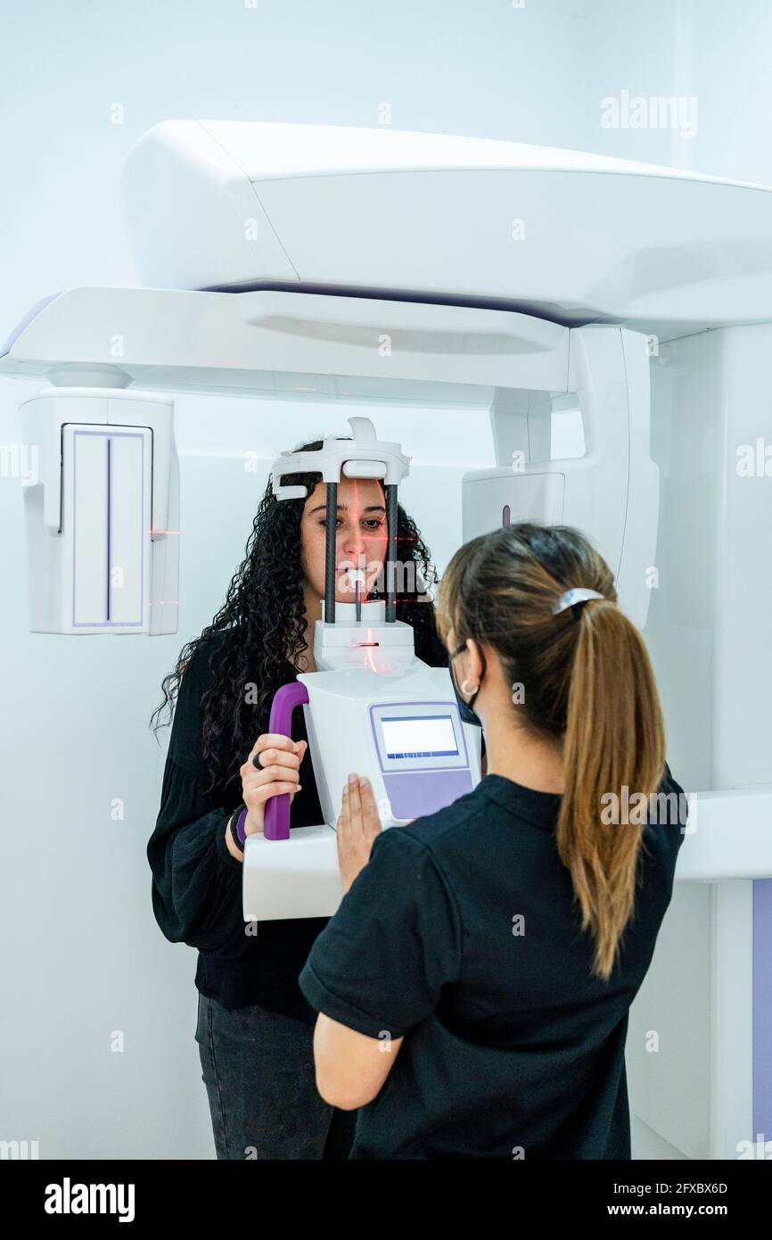 Dentiste féminin prenant des rayons X dentaires du patient en clinique Banque D'Images