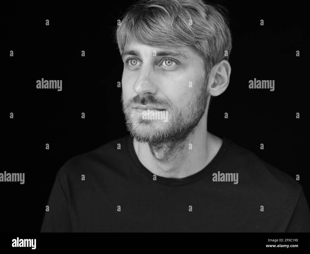 Un homme barbu rêvant sur fond noir Banque D'Images