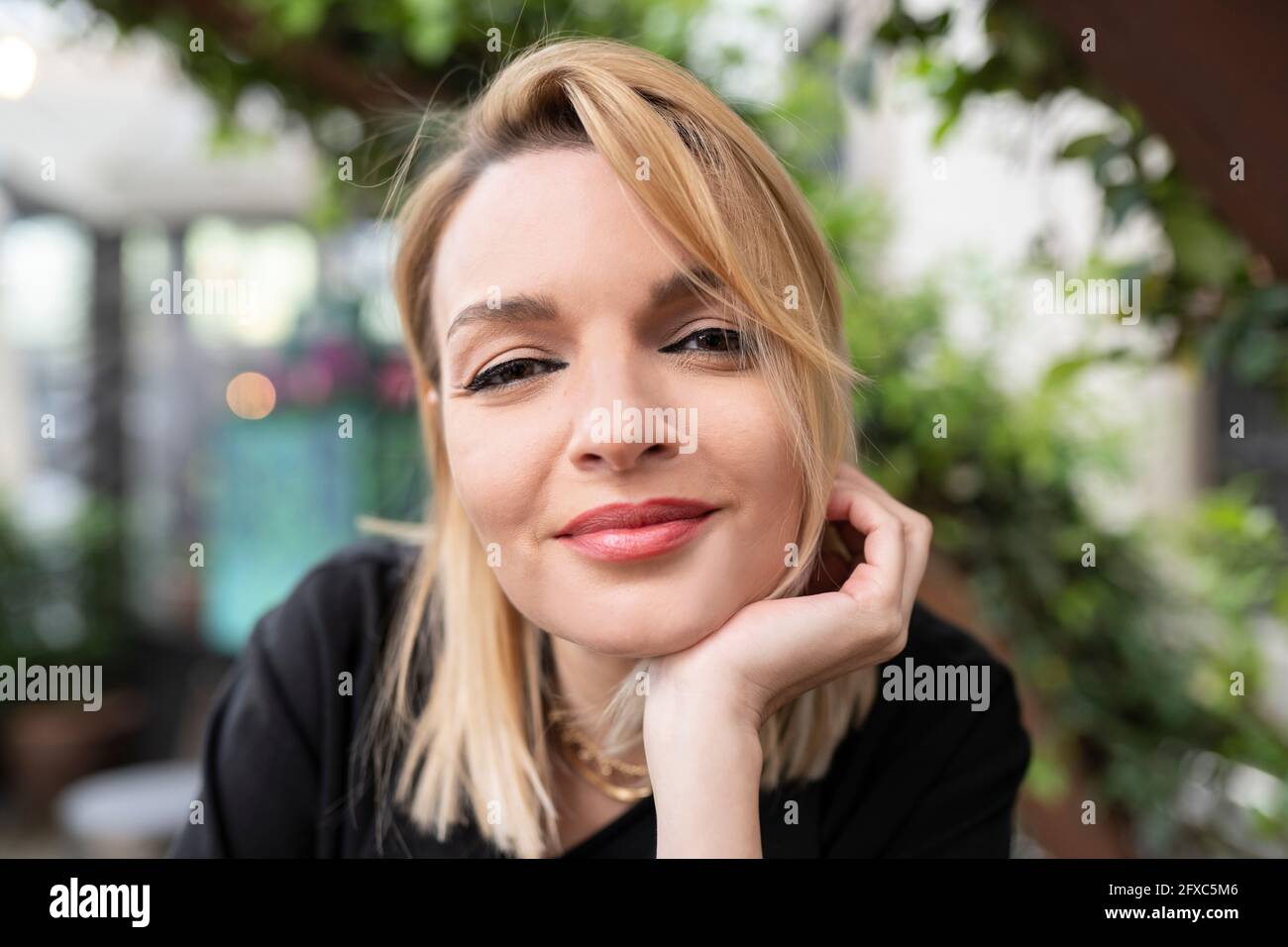 Smiling woman with hand on chin Banque D'Images