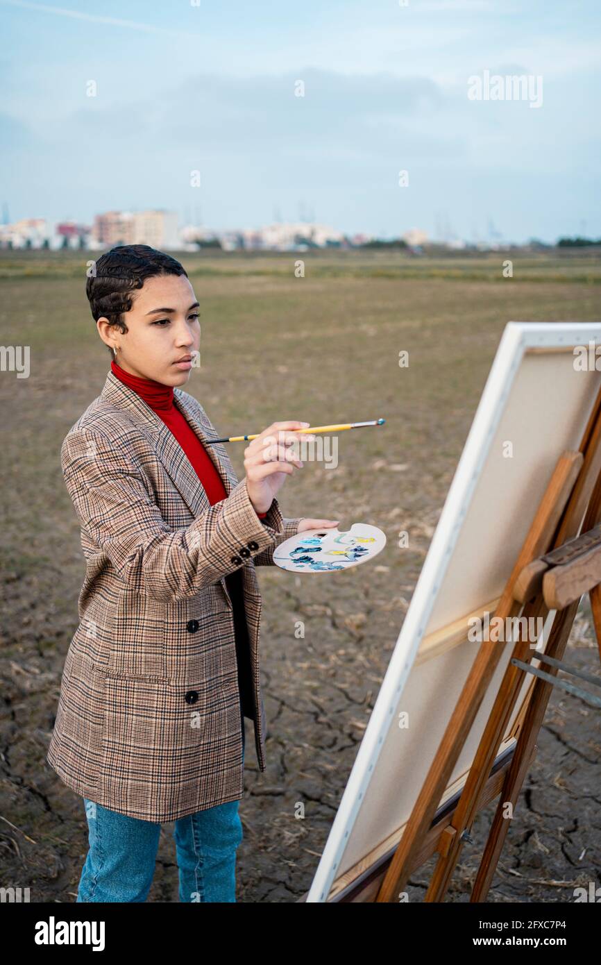 Femme avec la peinture de cheveux courts sur le champ agricole Banque D'Images