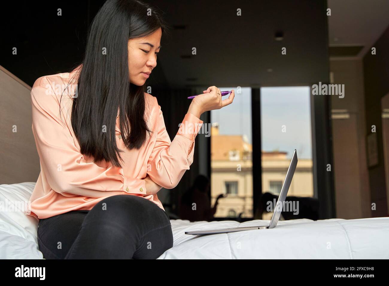 Une femme d'affaires remue-méninges en utilisant un ordinateur portable à l'hôtel Banque D'Images