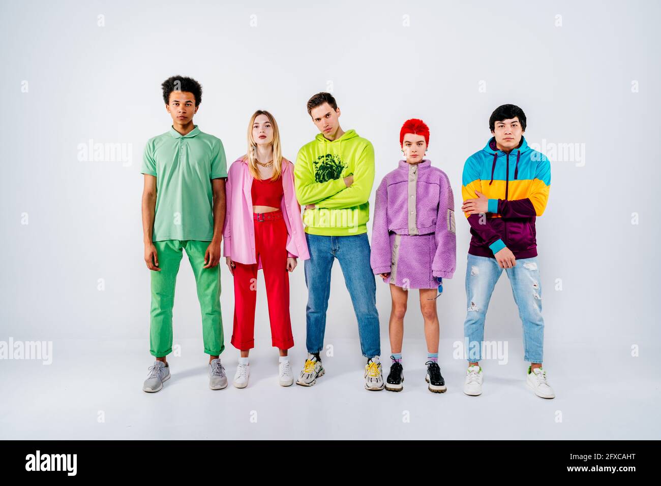 Groupe de jeunes cool dans des vêtements colorés debout sur fond blanc Banque D'Images