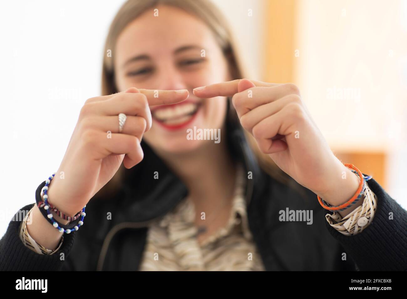 Femme souriante jouant avec le doigt Banque D'Images