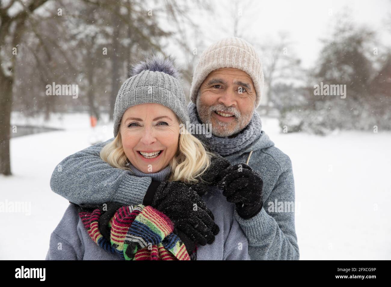 Homme âgé avec le bras autour de la femme au parc pendant l'hiver Banque D'Images