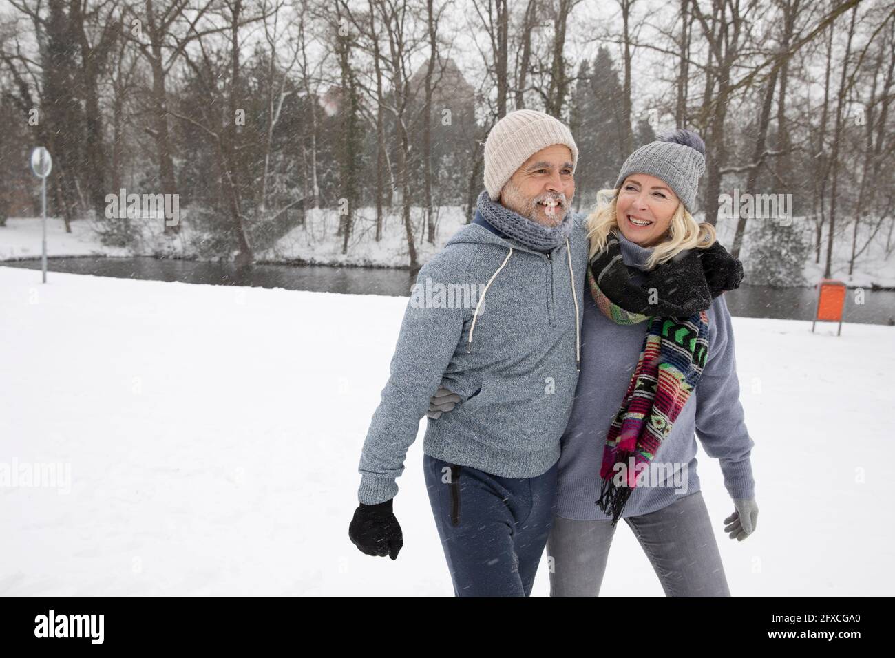 Homme âgé avec le bras autour de la femme marchant dans le parc Banque D'Images