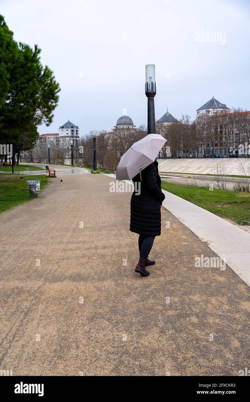 Femme avec un parapluie par jour de pluie sur le quai de la rivière Lez  dans la ville de Montpellier, France Photo Stock - Alamy