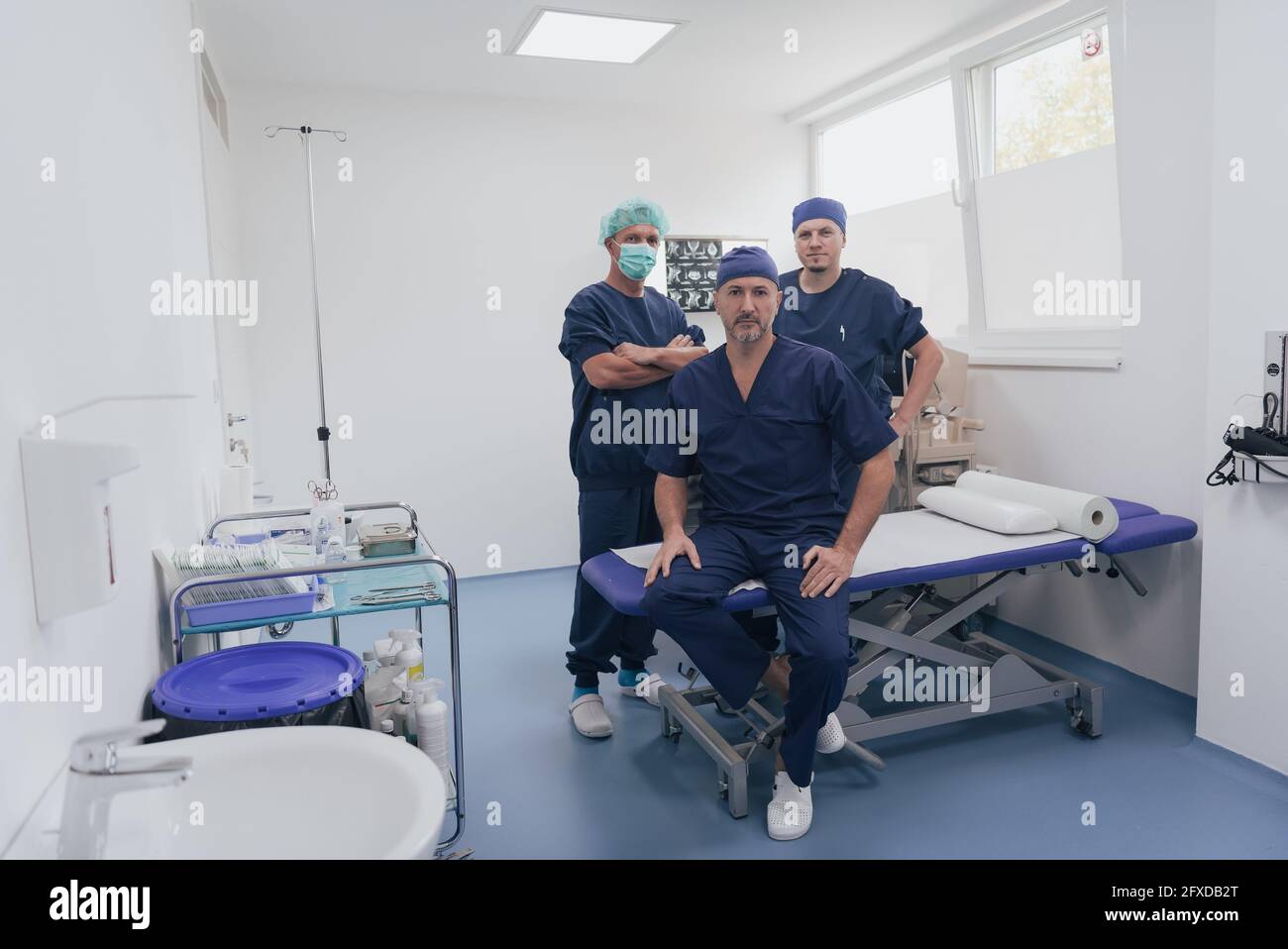 Médecin orthopédique multiethnique devant son équipe médicale à l'appareil photo portant un masque facial Banque D'Images