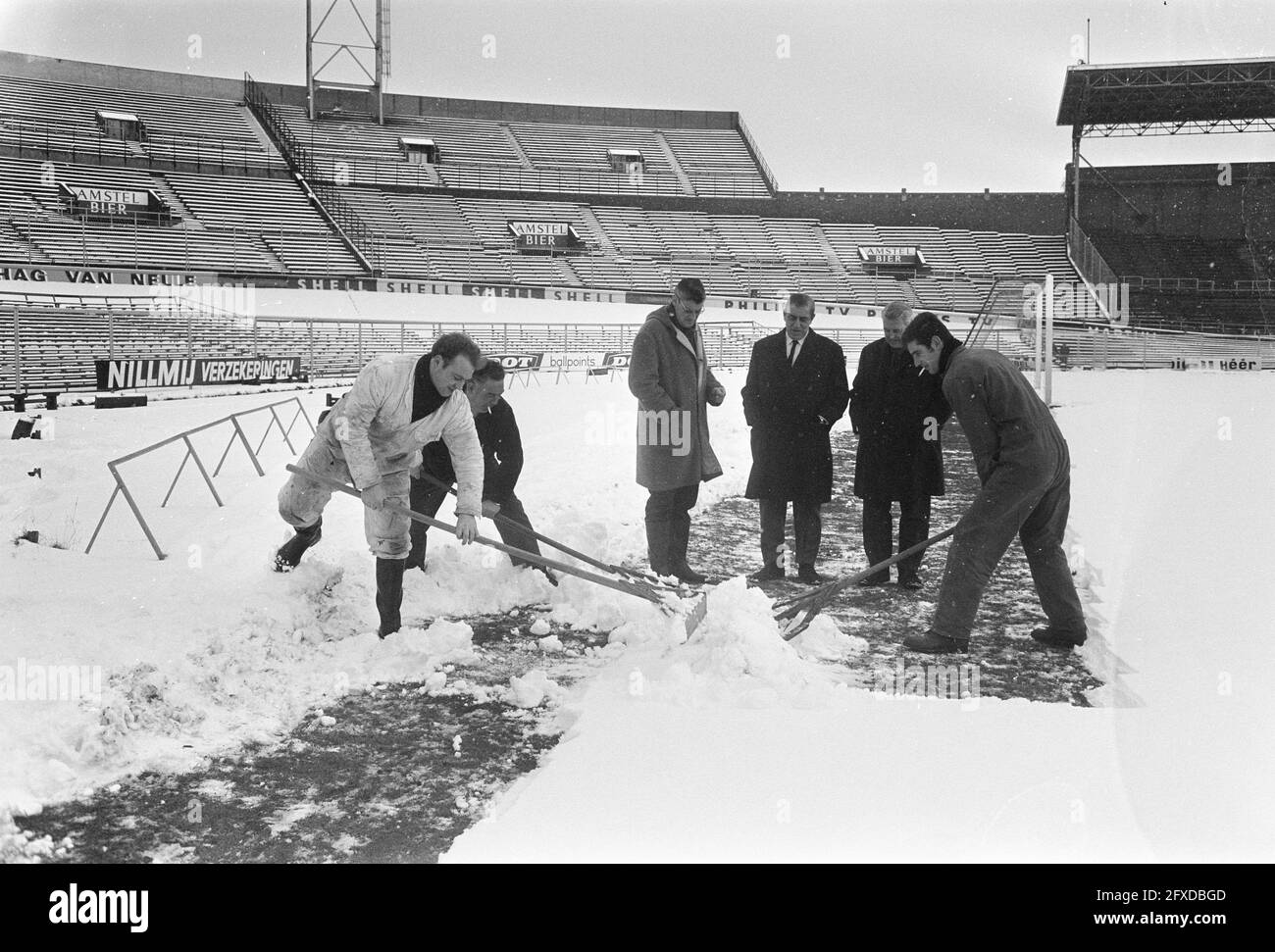 Déneigement dans le stade olympique avant le match Ajax contre Benfica le terrain est en cours de déneigement, 10 février 1969, SCHOONMAKERS, SNEEUWRUIMEN, stades, Matches, pays-Bas, agence de presse du XXe siècle photo, news to remember, documentaire, photographie historique 1945-1990, histoires visuelles, L'histoire humaine du XXe siècle, immortaliser des moments dans le temps Banque D'Images